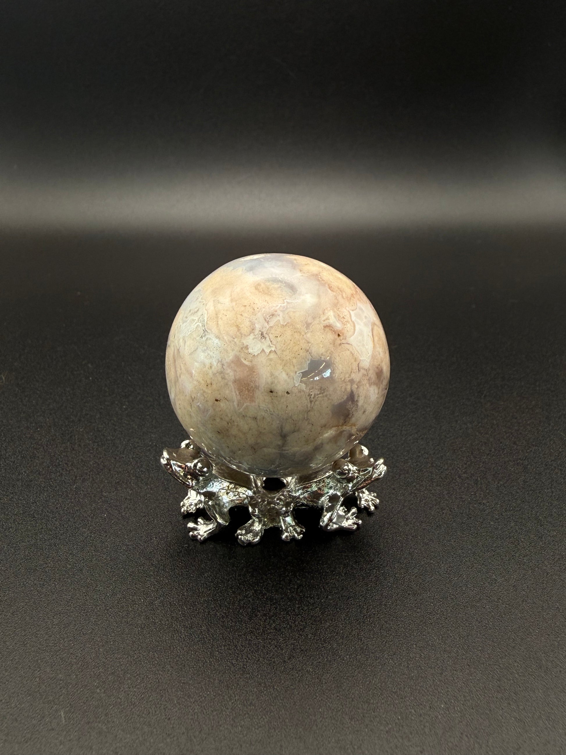 Flower agate polished crystal in the shape of a sphere.