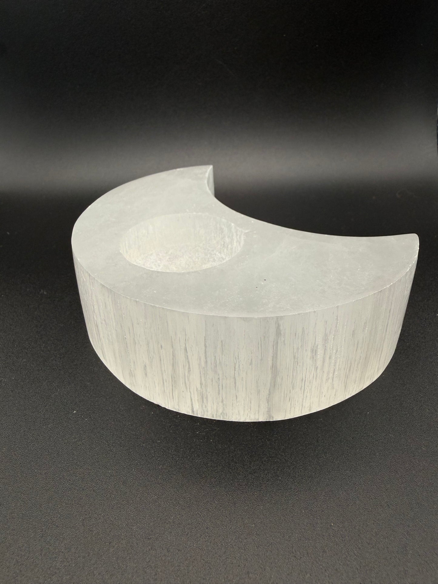 Selenite candle holder in the shape of a moon.