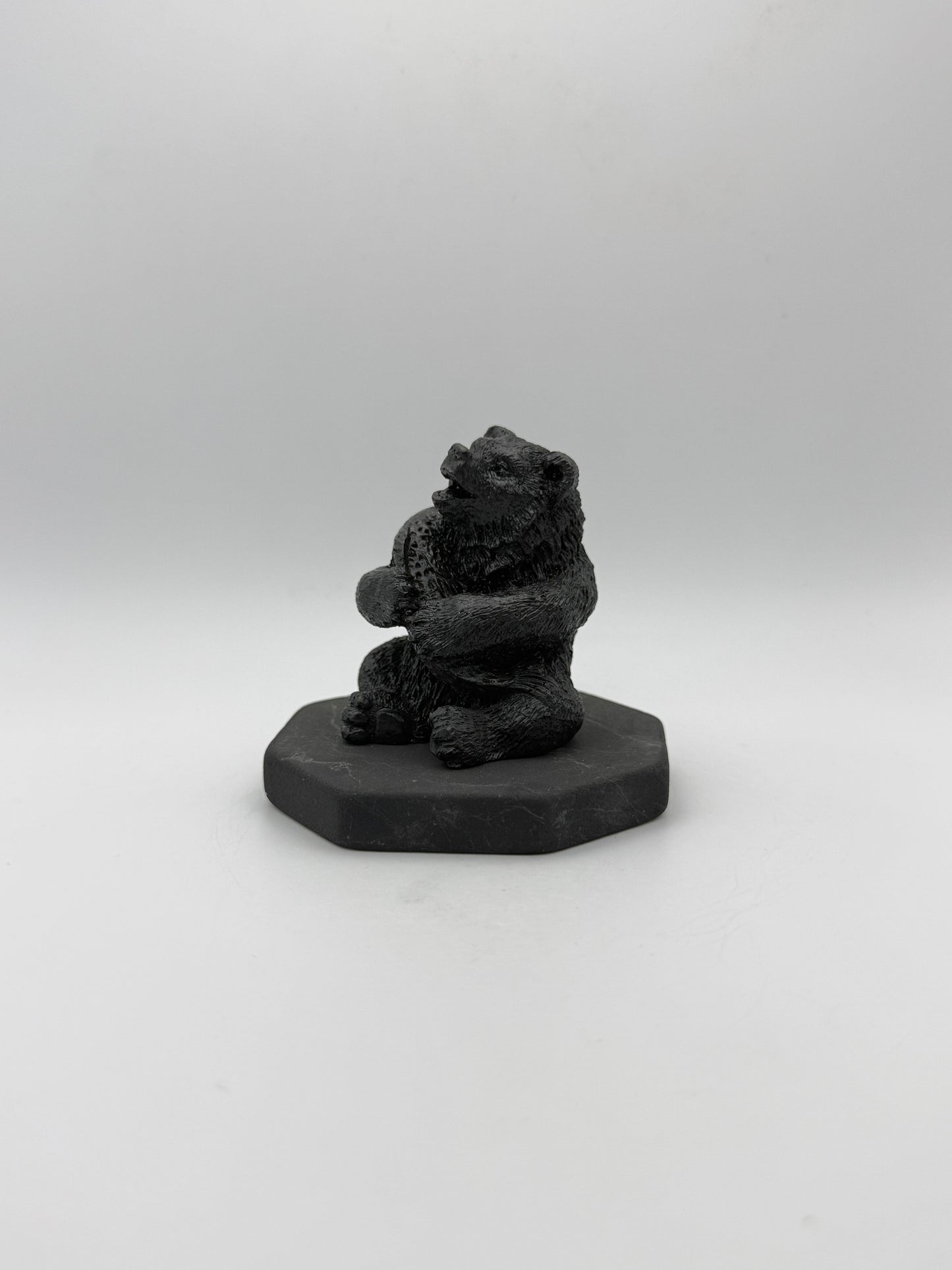 Shungite carving of a bear holding a fish.