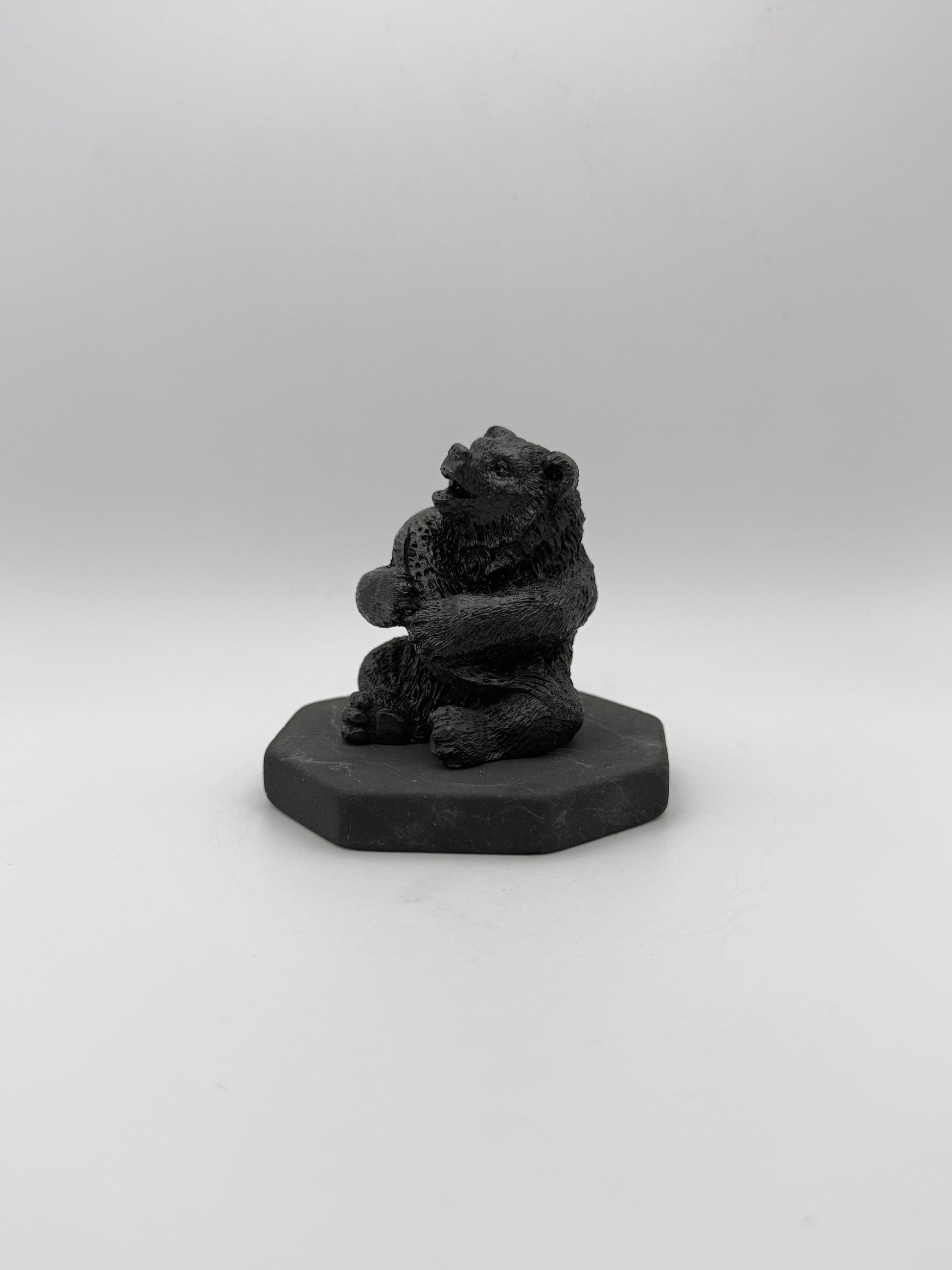 Shungite carving of a bear holding a fish.