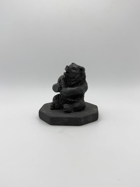 Shungite carving of a bear holding a fish.