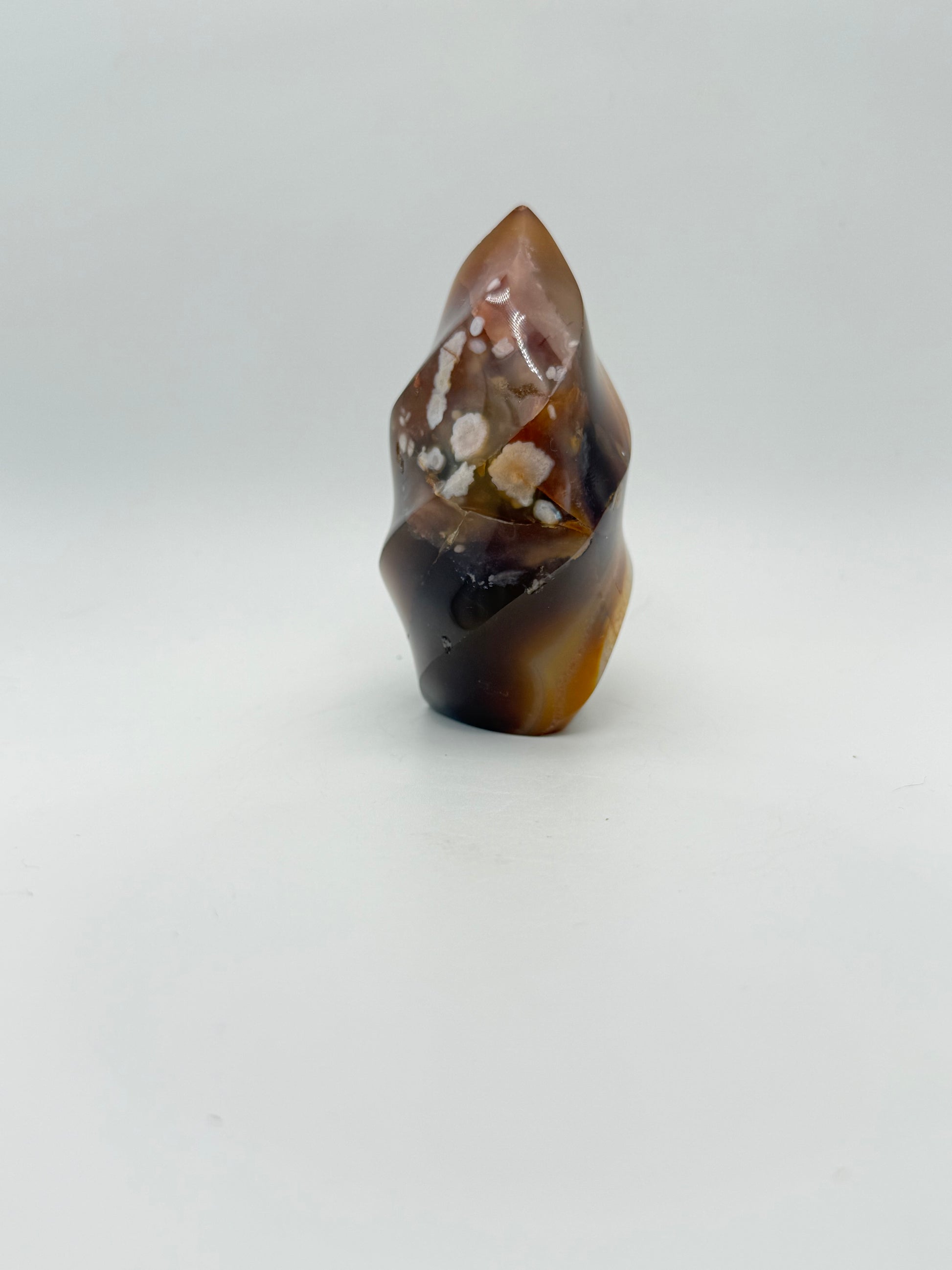 A polished carnelian stone with a flame shape, featuring an orange to red gradient color.