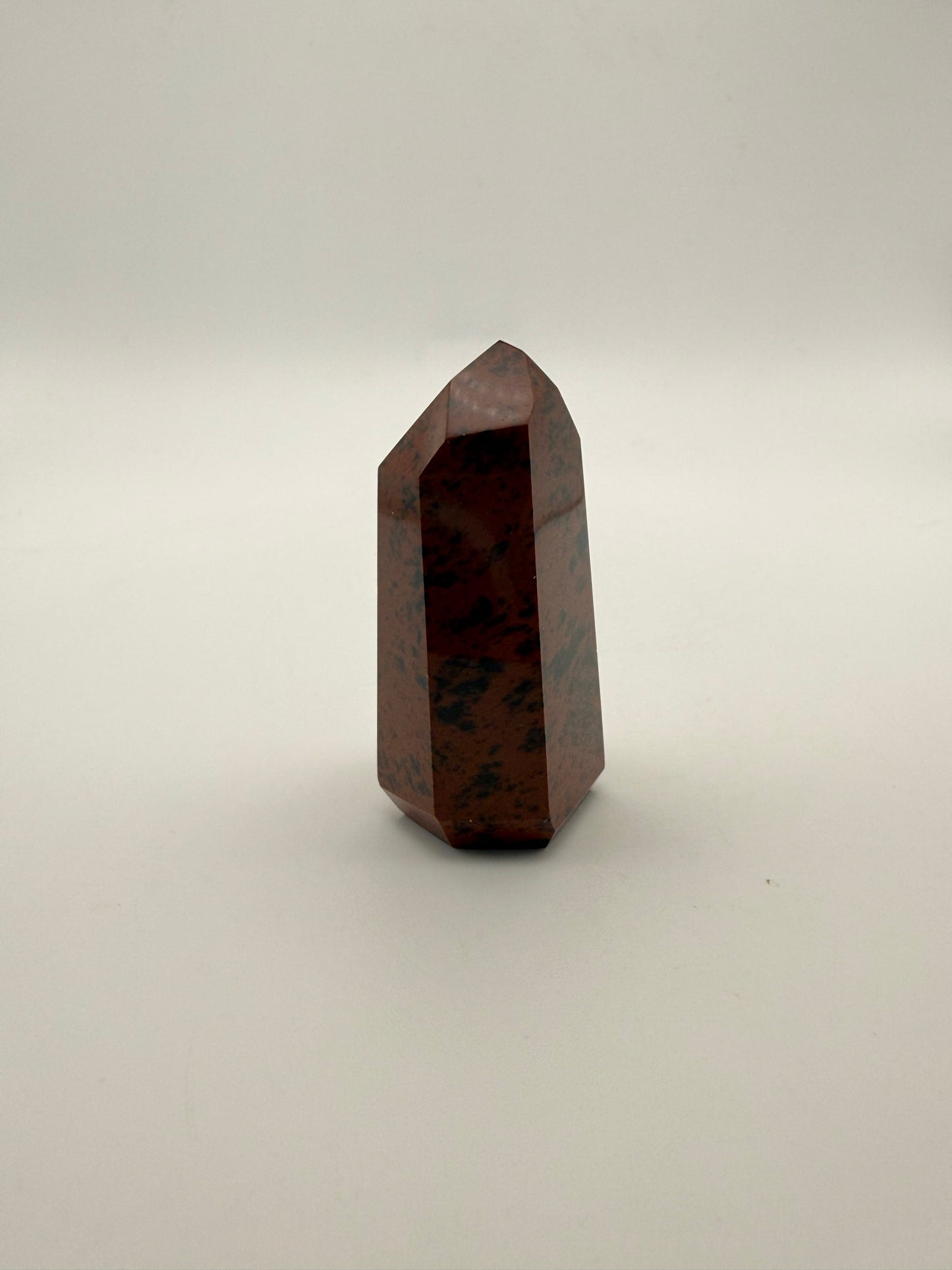Polished mahogany obsidian tower with six sides.