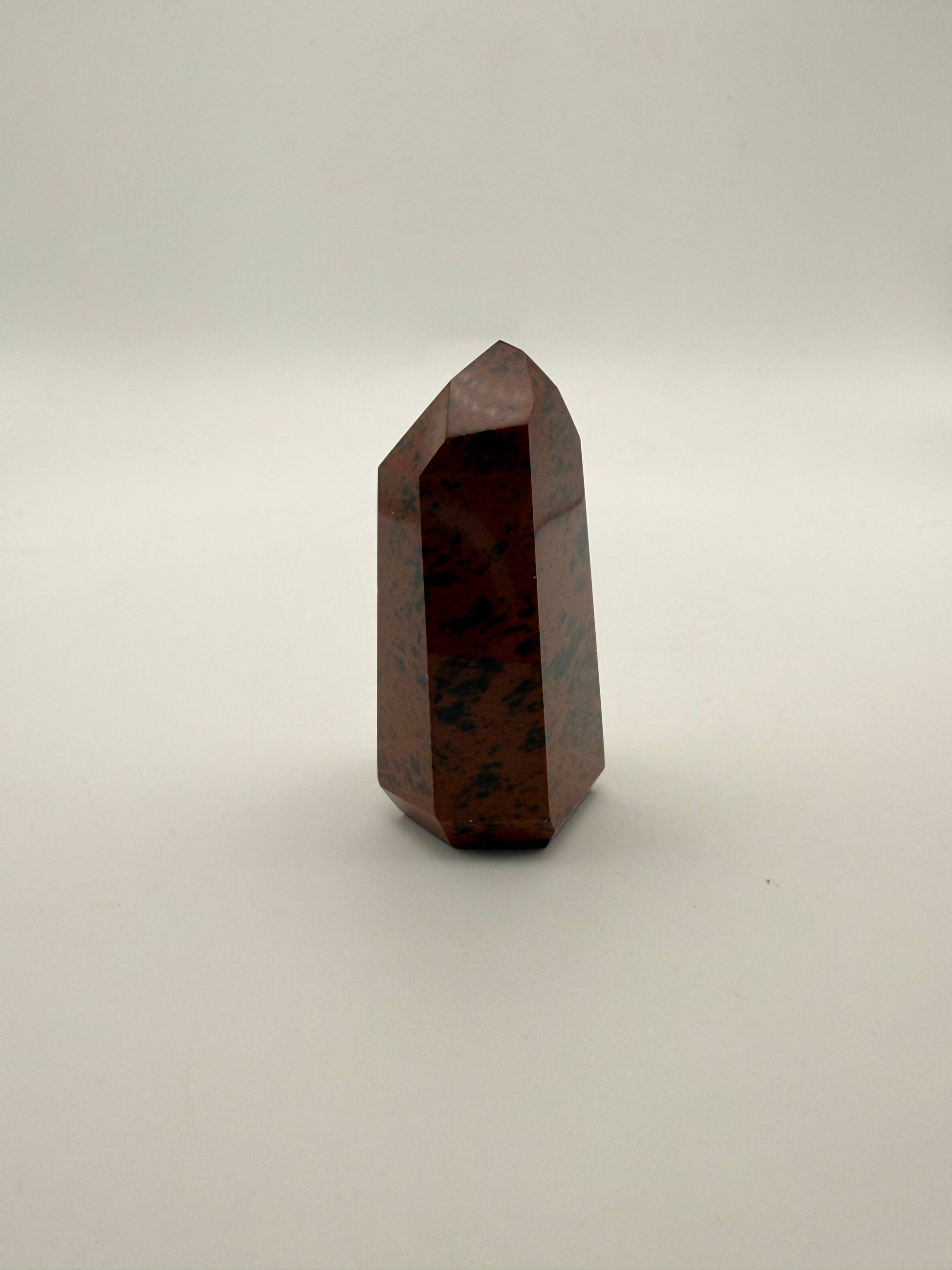 Polished mahogany obsidian tower with six sides.