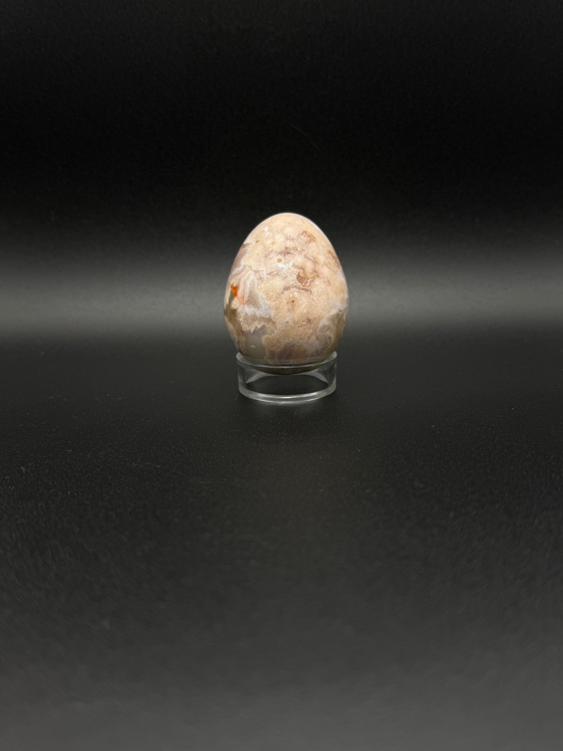 Polished flower agate crystal in the shape of an egg.