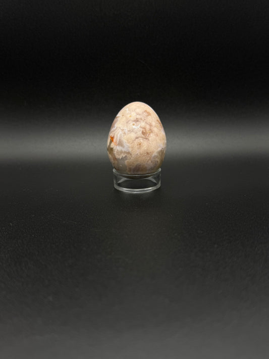 Polished flower agate crystal in the shape of an egg.