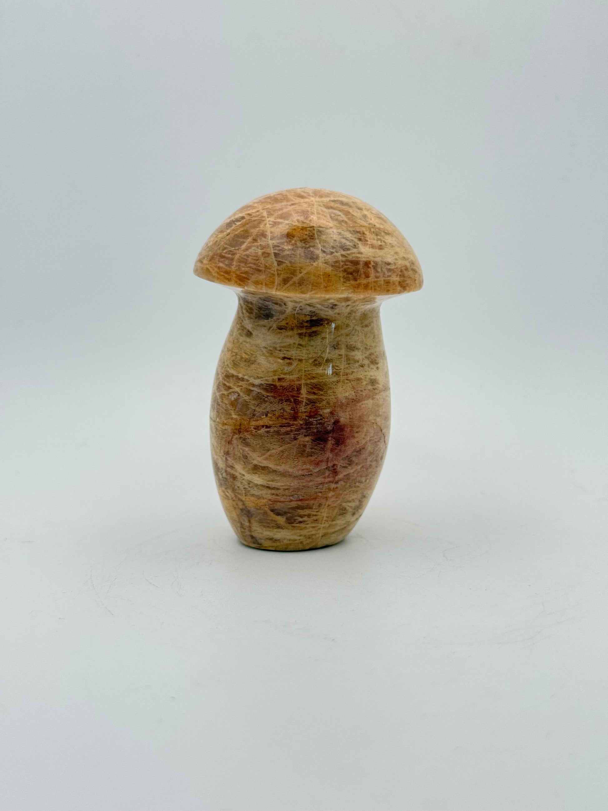 Polished yellow moonstone in the shape of a mushroom.
