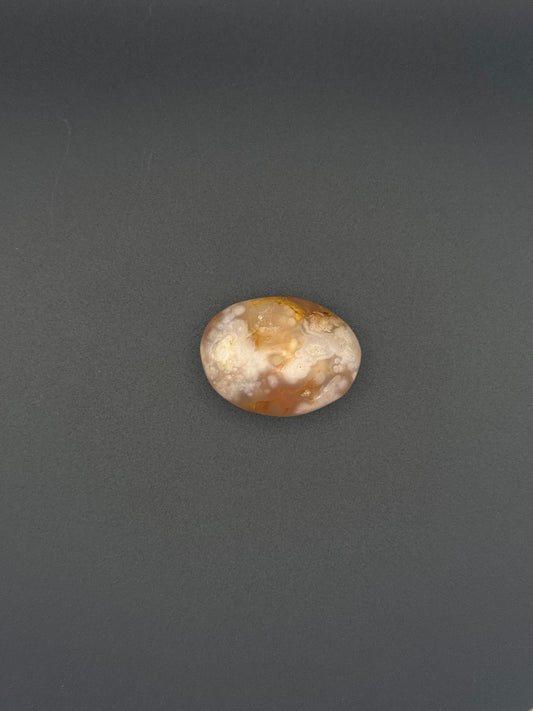 Flower agate polished crystal in the shape of a palm stone.