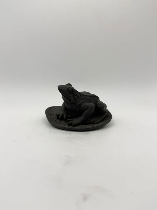 Shungite carving of a frog on a leaf.