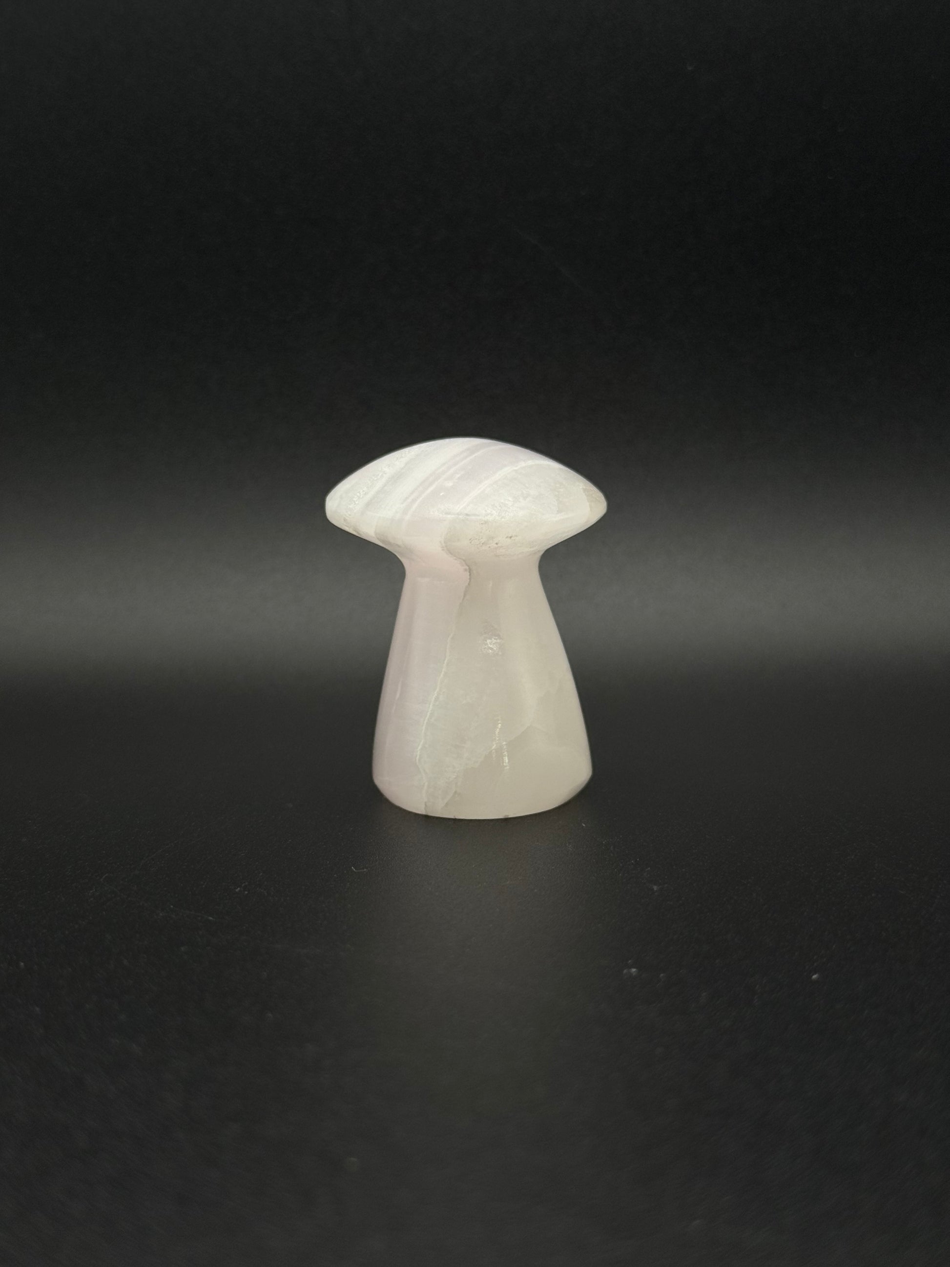 Polished pink calcite mushroom. Pink calcite glows under uv light.