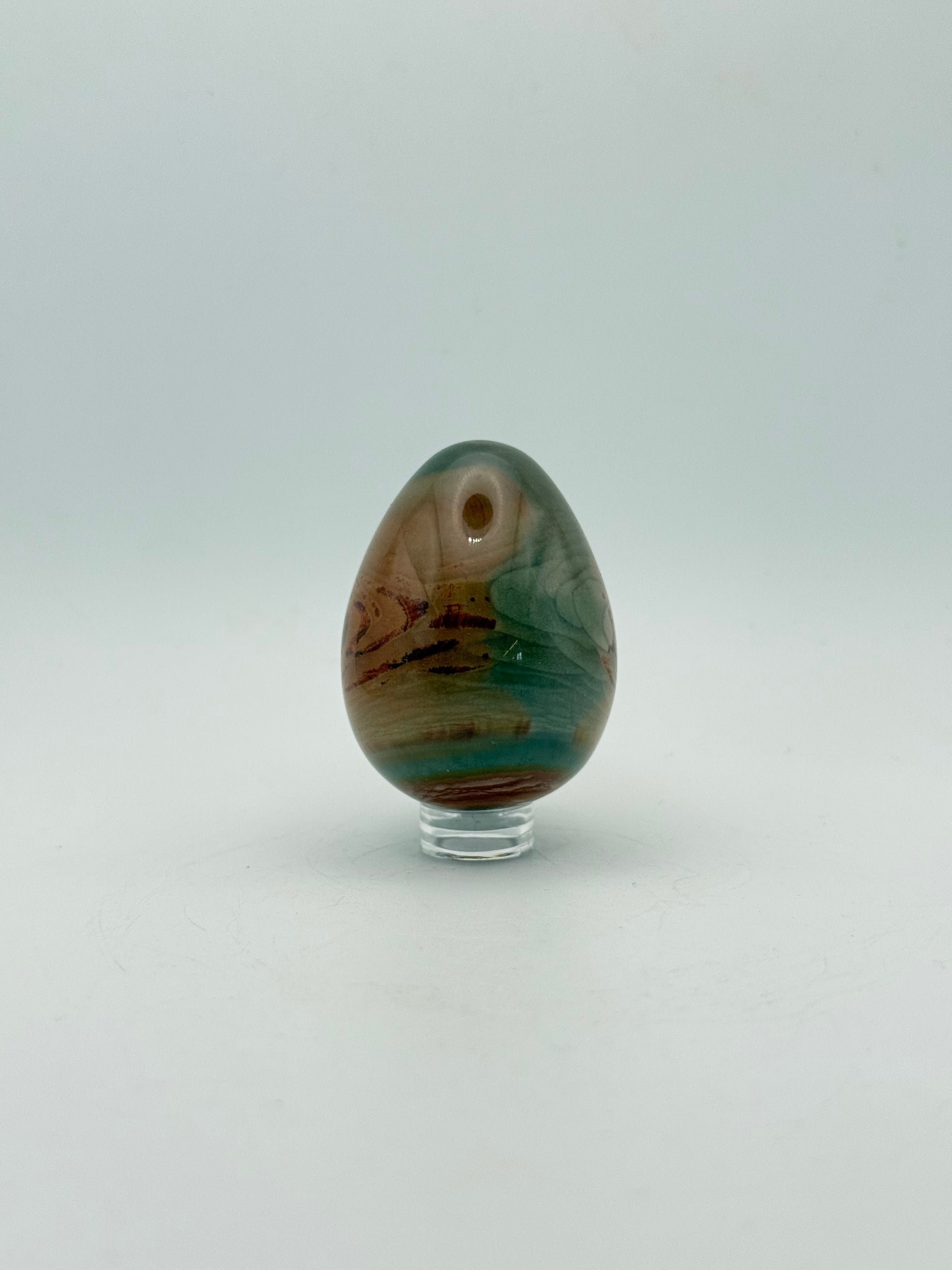 Polished polychrome jasper shaped into an egg.