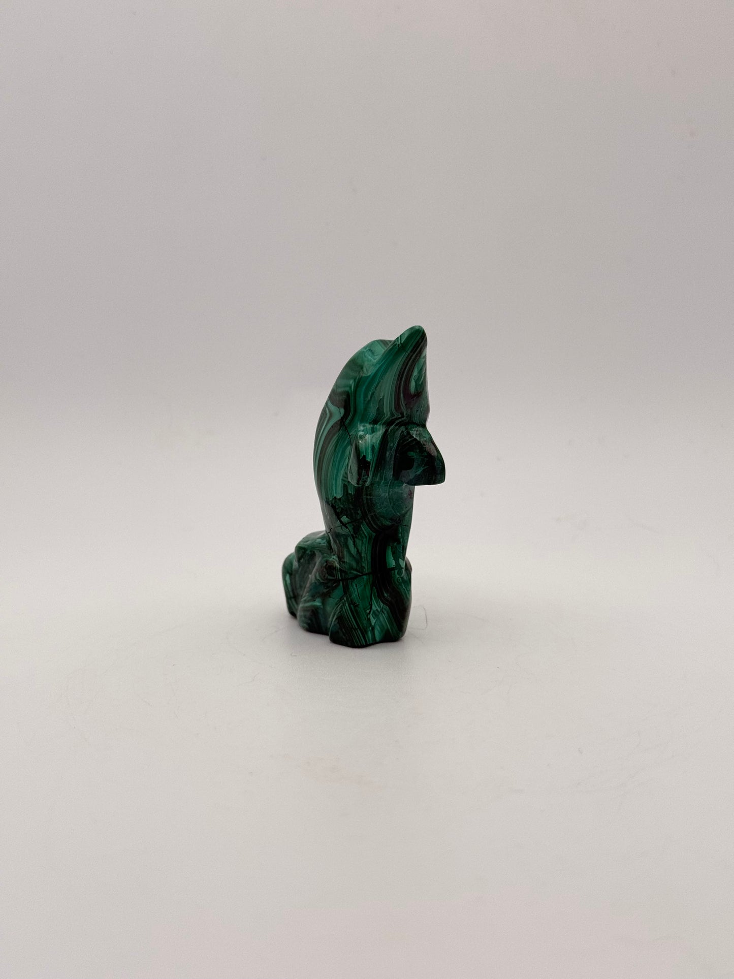 Polished malachite dolphin carving.