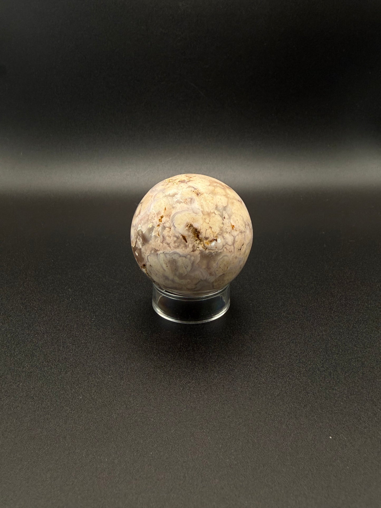 Flower agate polished crystal in the shape of a sphere.
