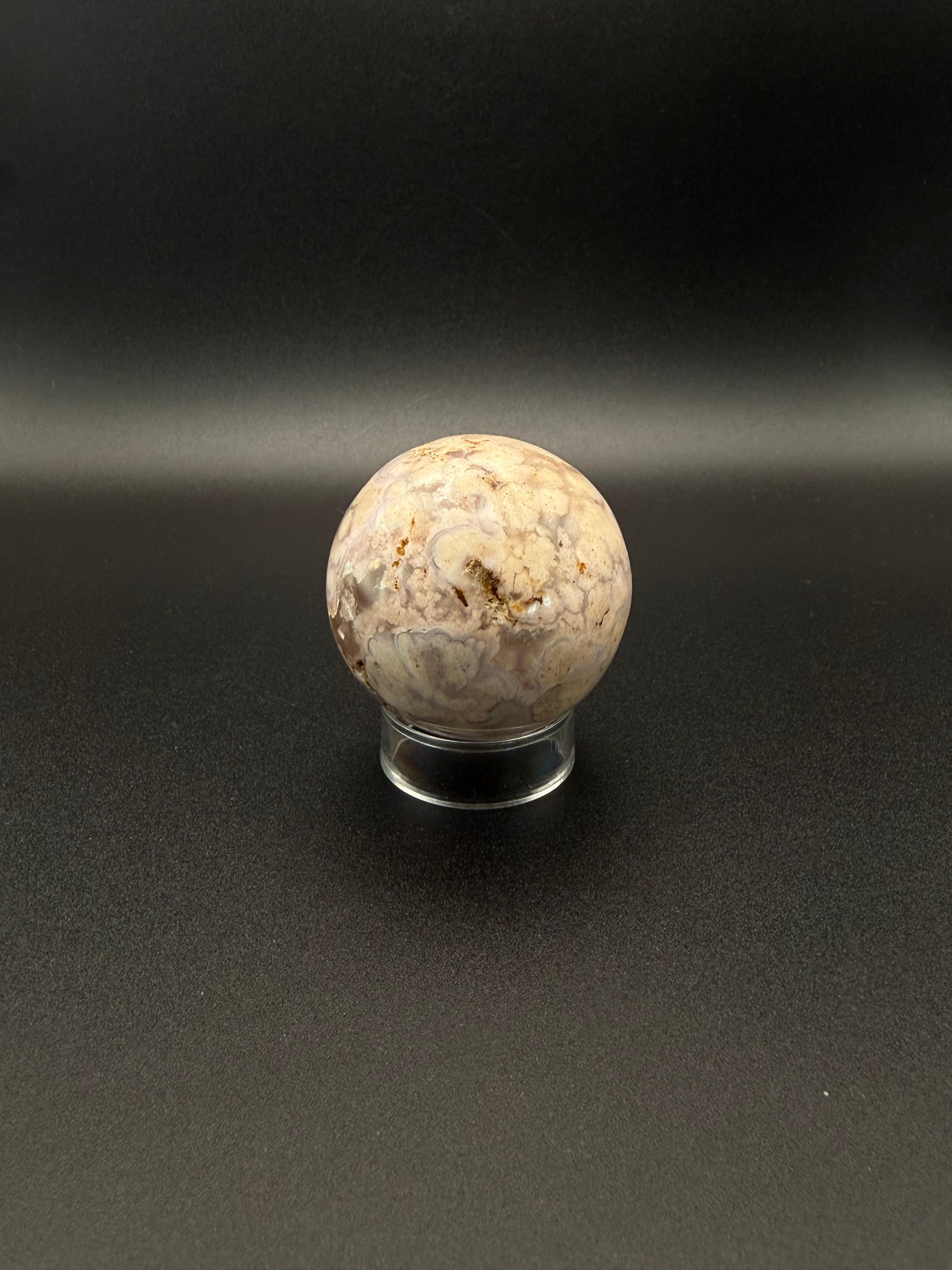 Flower agate polished crystal in the shape of a sphere.