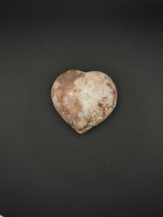 Flower agate polished crystal in the shape of a heart.