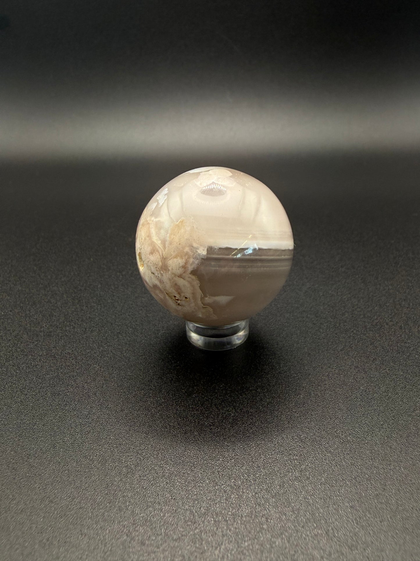 Flower agate polished crystal in the shape of a sphere.