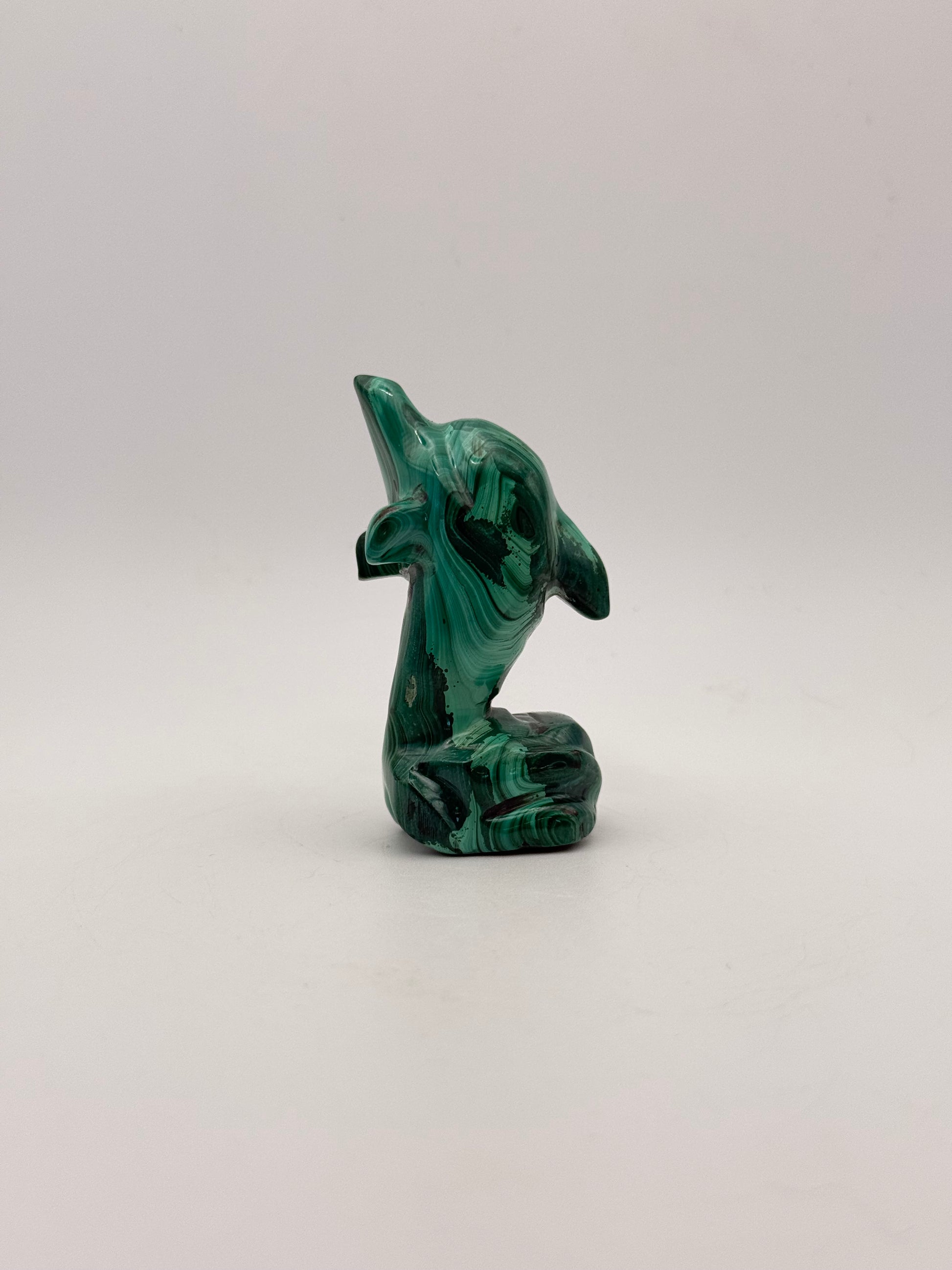 Polished malachite dolphin carving.
