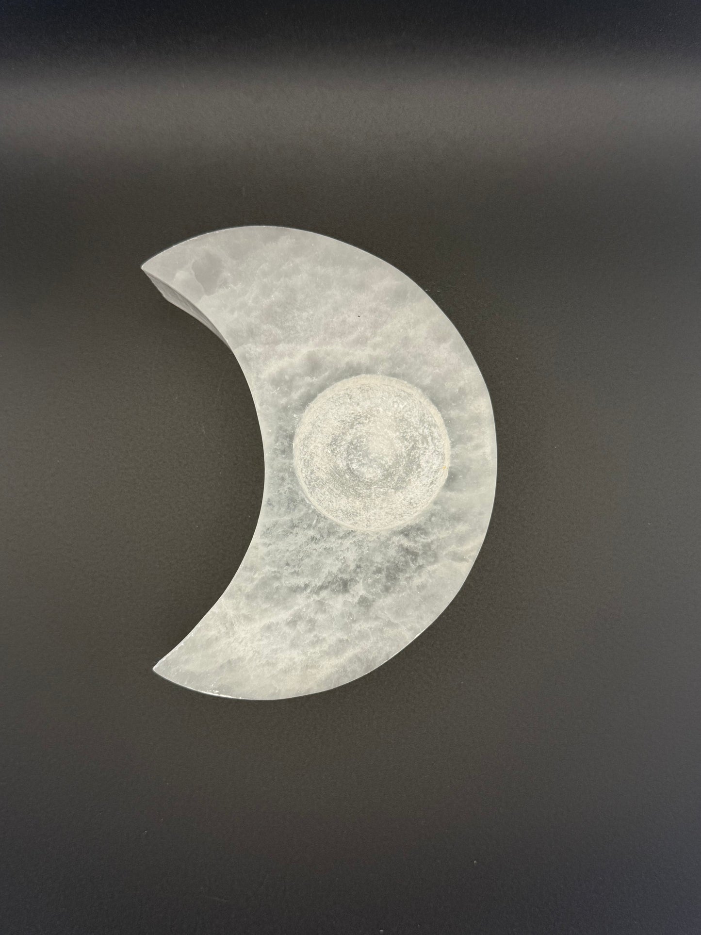 Selenite candle holder in the shape of a moon.