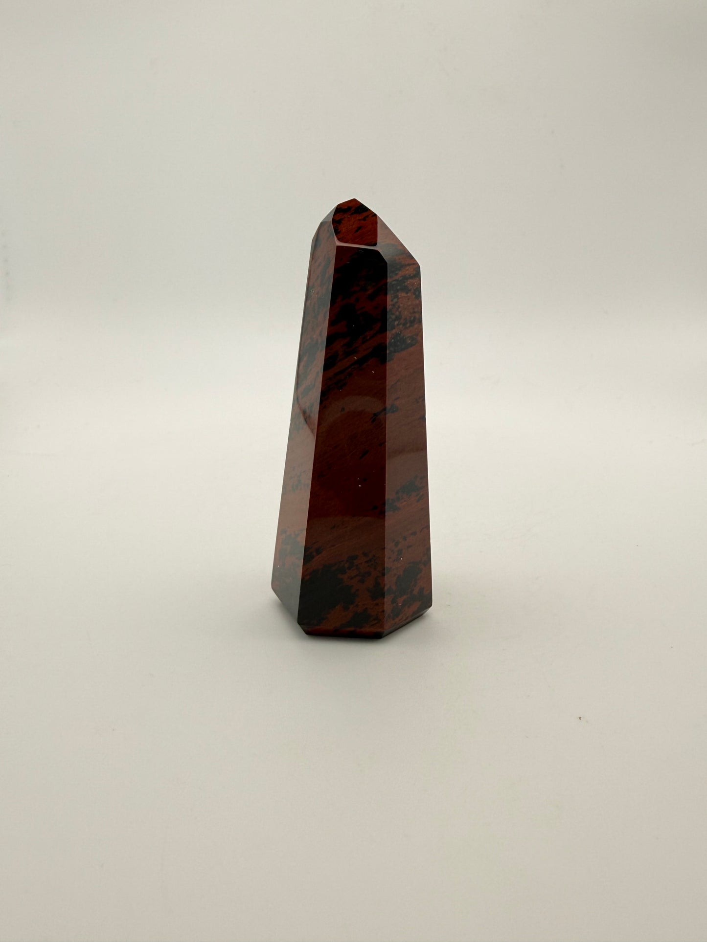 Polished mahogany obsidian tower with six sides.