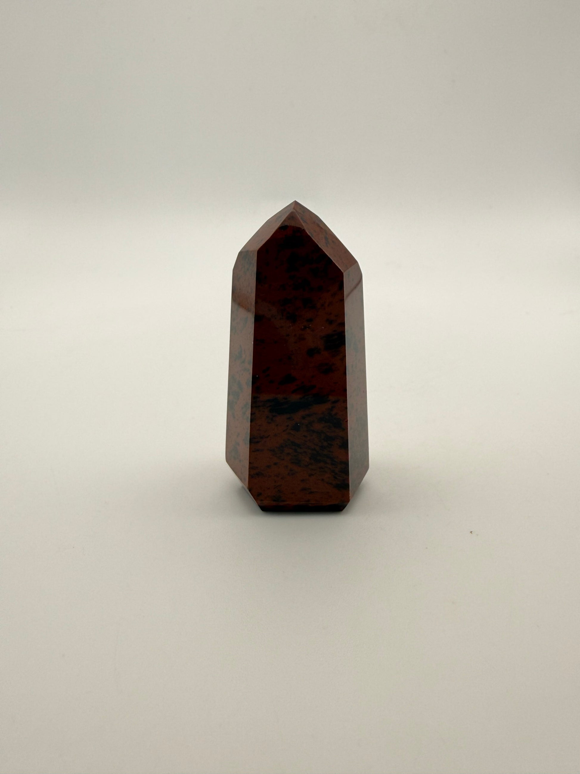 Polished mahogany obsidian tower with six sides.