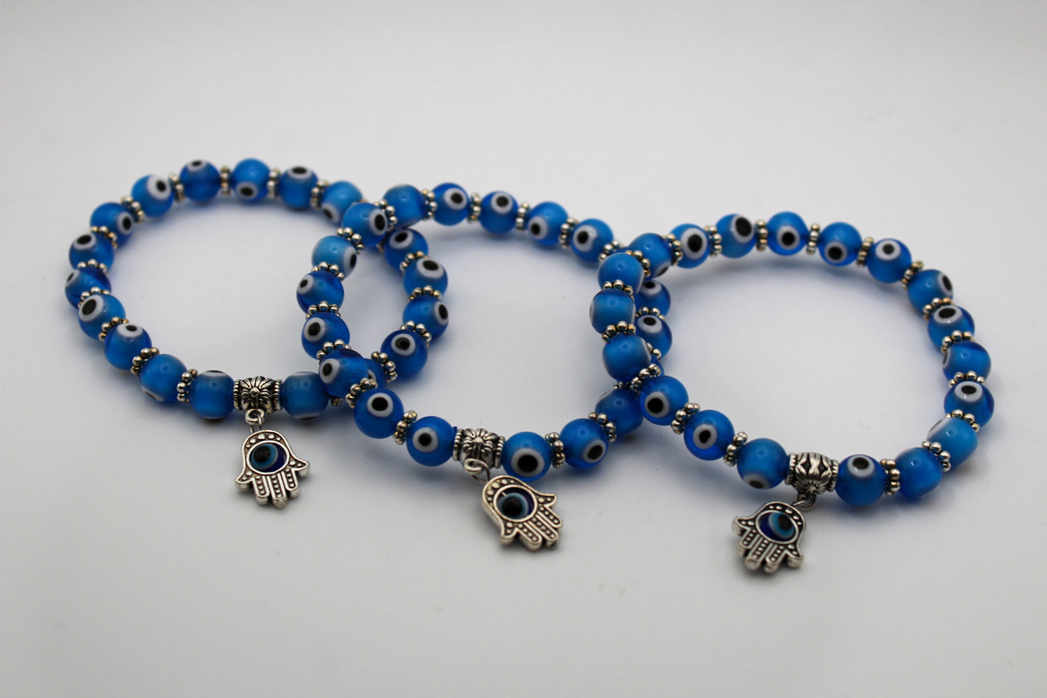 Blue colored evil eye bracelets with an evil eye charm.