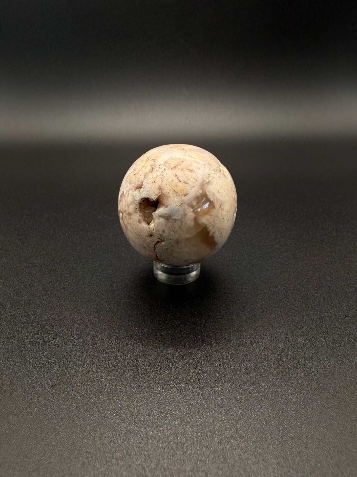 Flower agate polished crystal in the shape of a sphere.