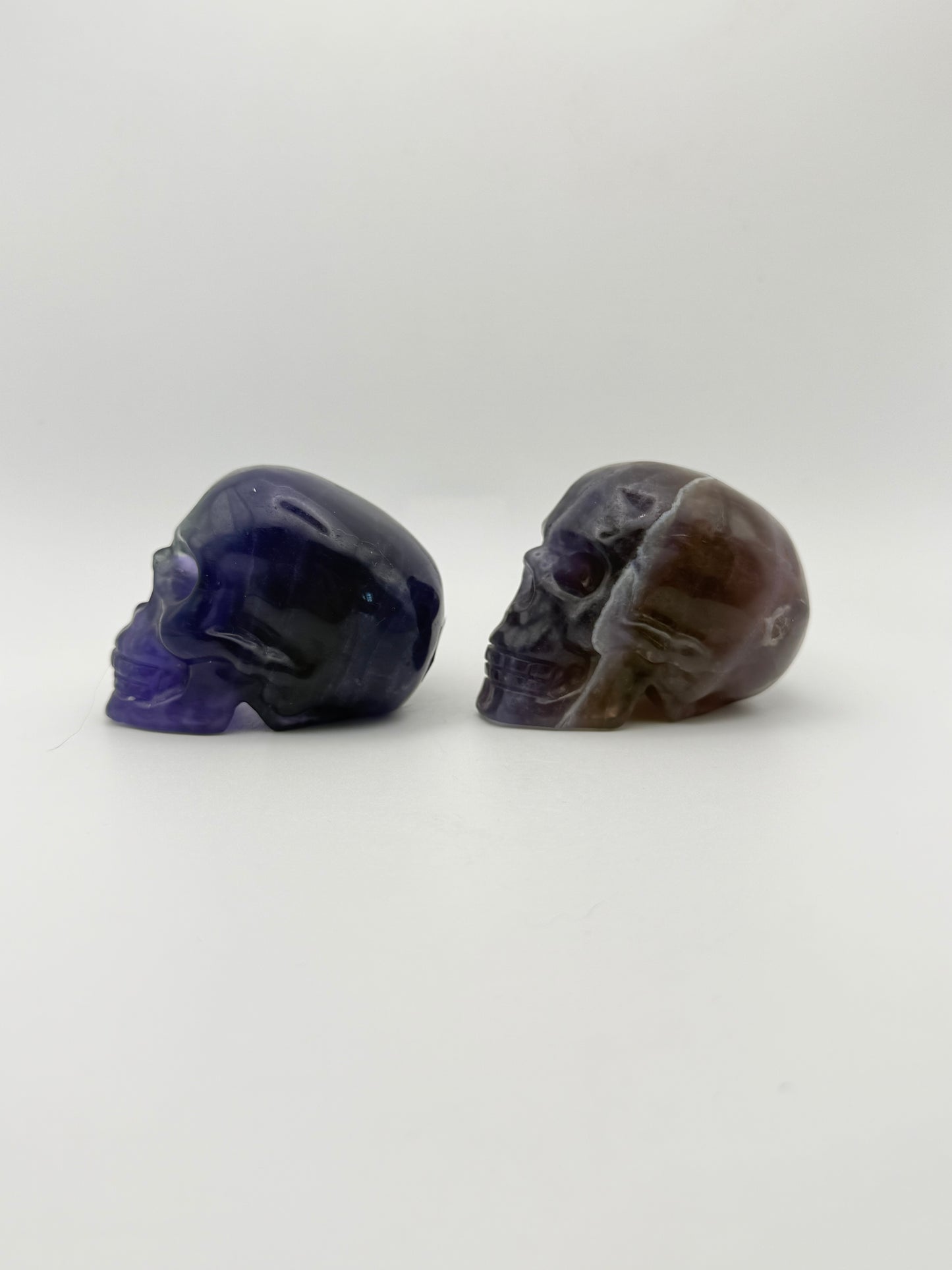 Two purple fluorite polished stone skulls.