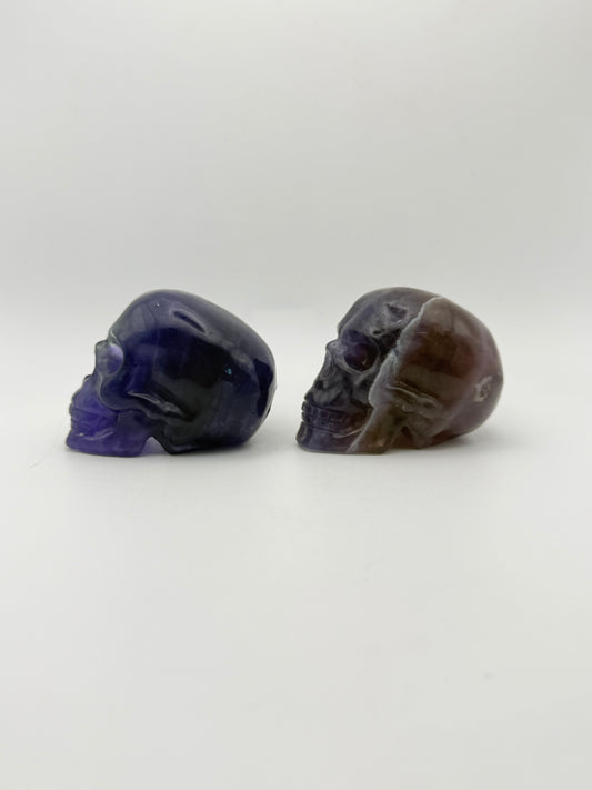Two purple fluorite polished stone skulls.