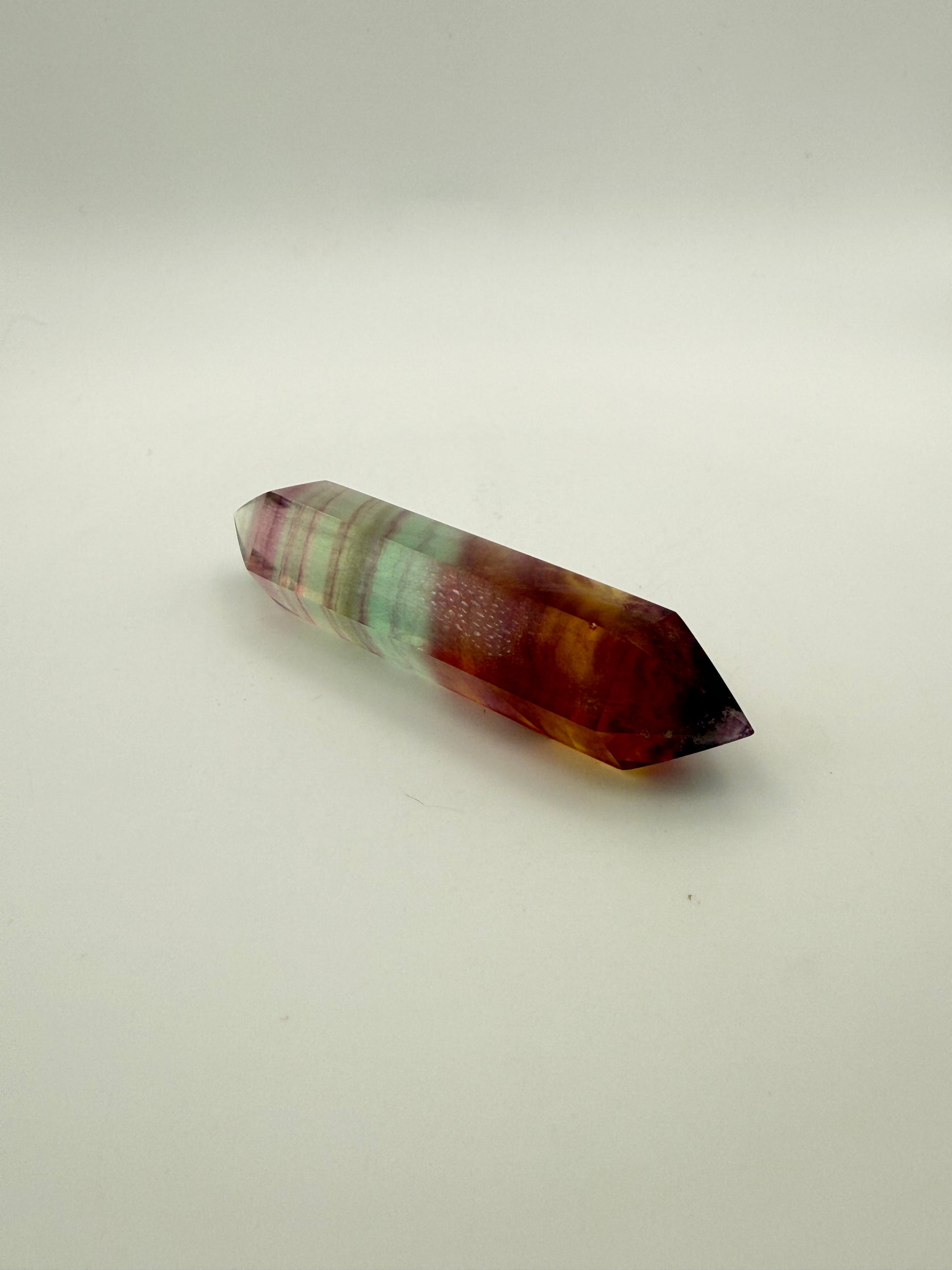 Rainbow Fluorite polished crystal in the shape of a double term.