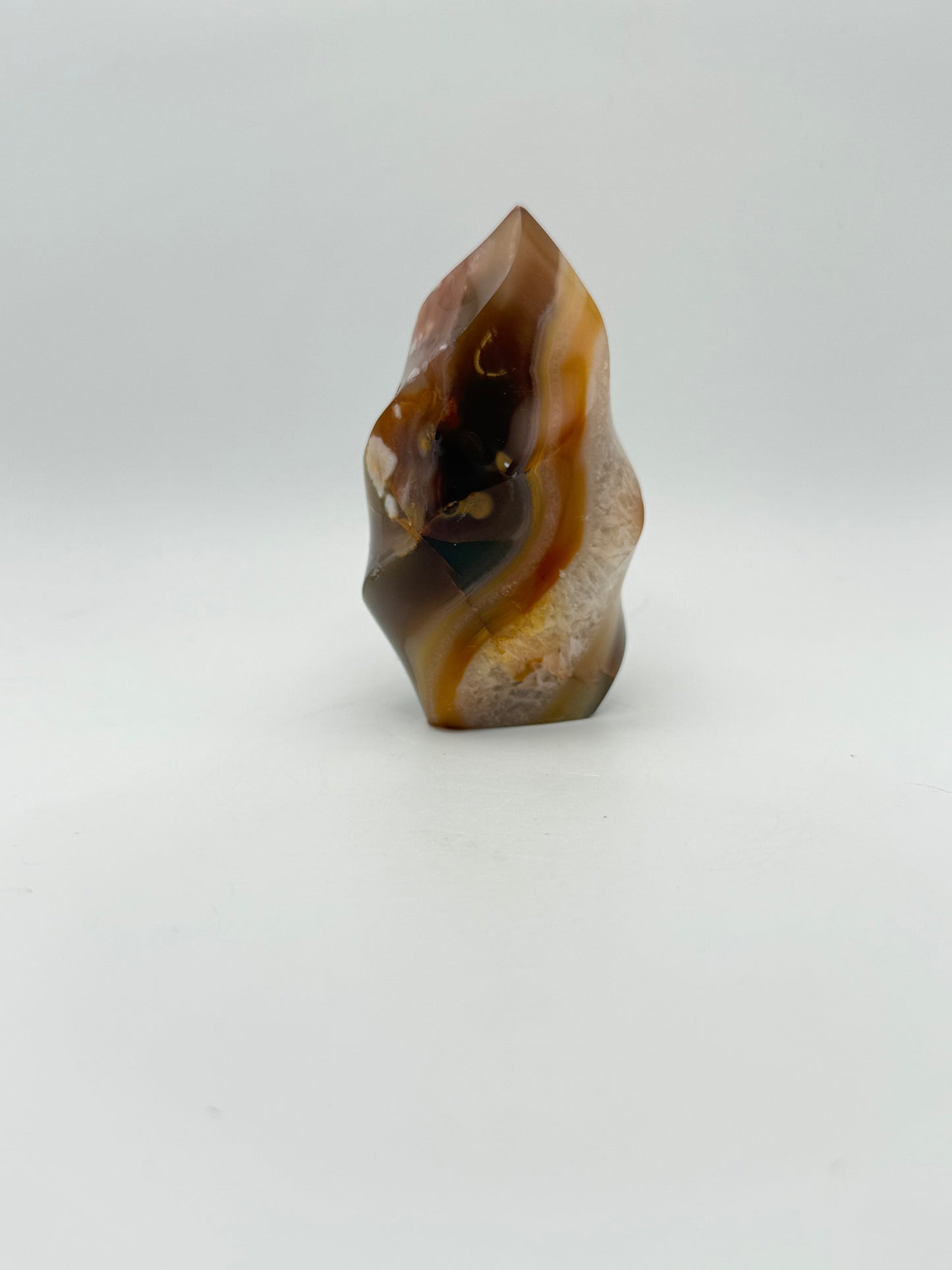 A polished carnelian stone with a flame shape, featuring an orange to red gradient color.