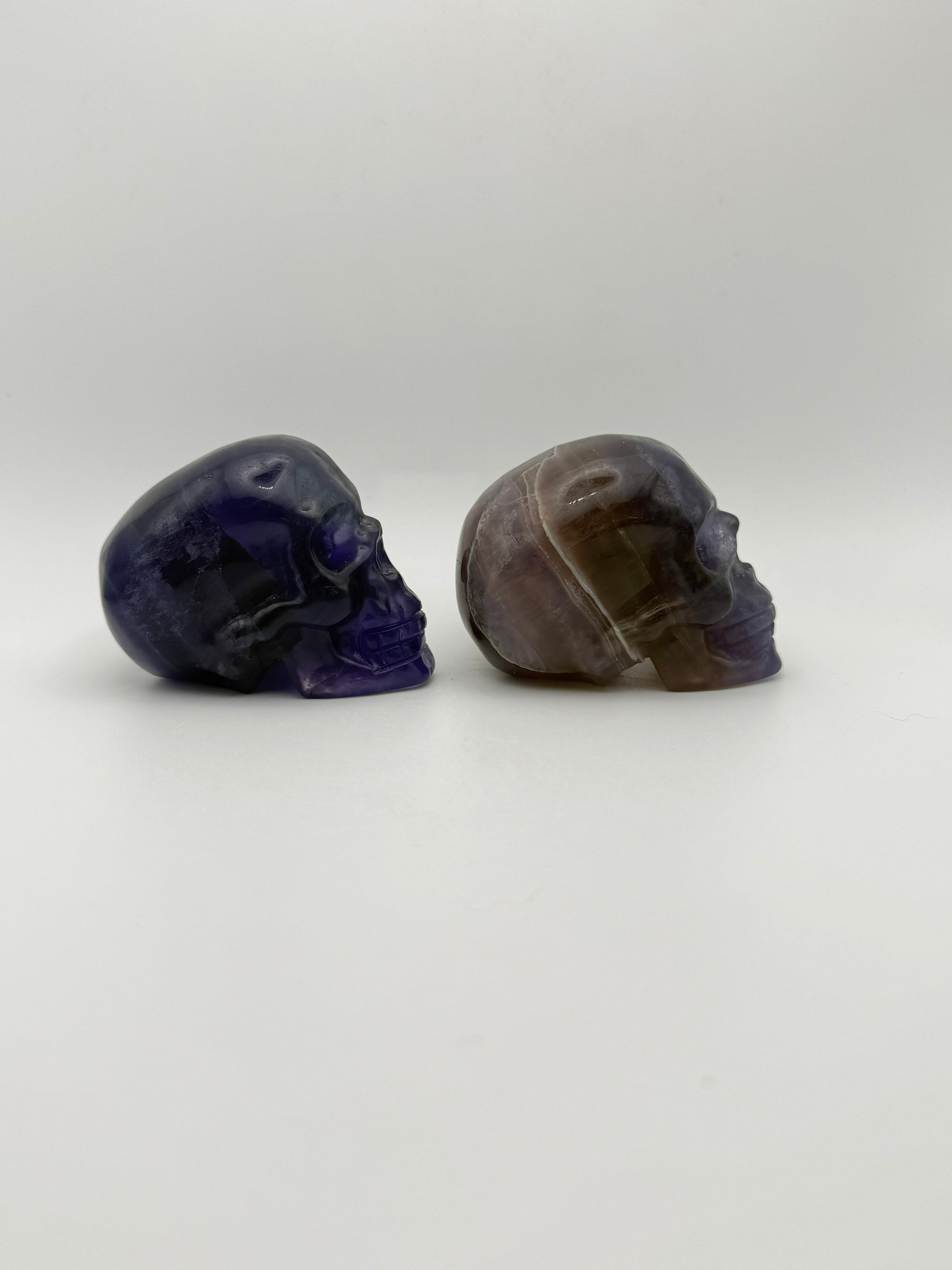 Two purple fluorite polished stone skulls.
