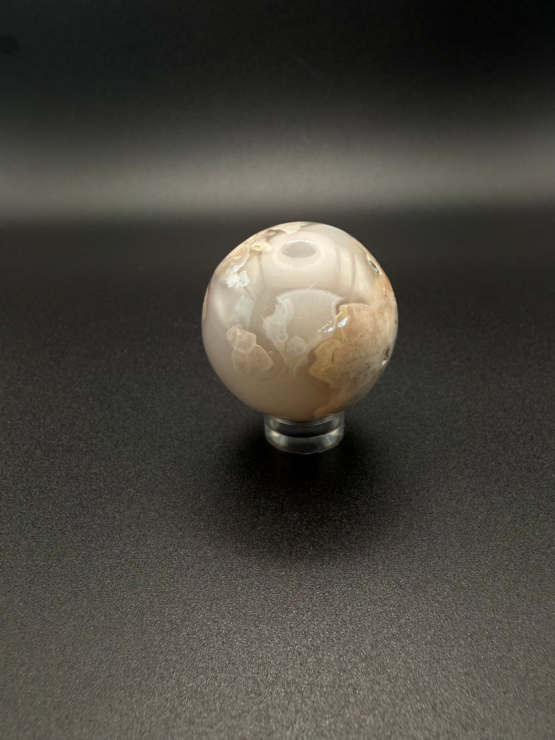 Flower agate polished crystal in the shape of a sphere.
