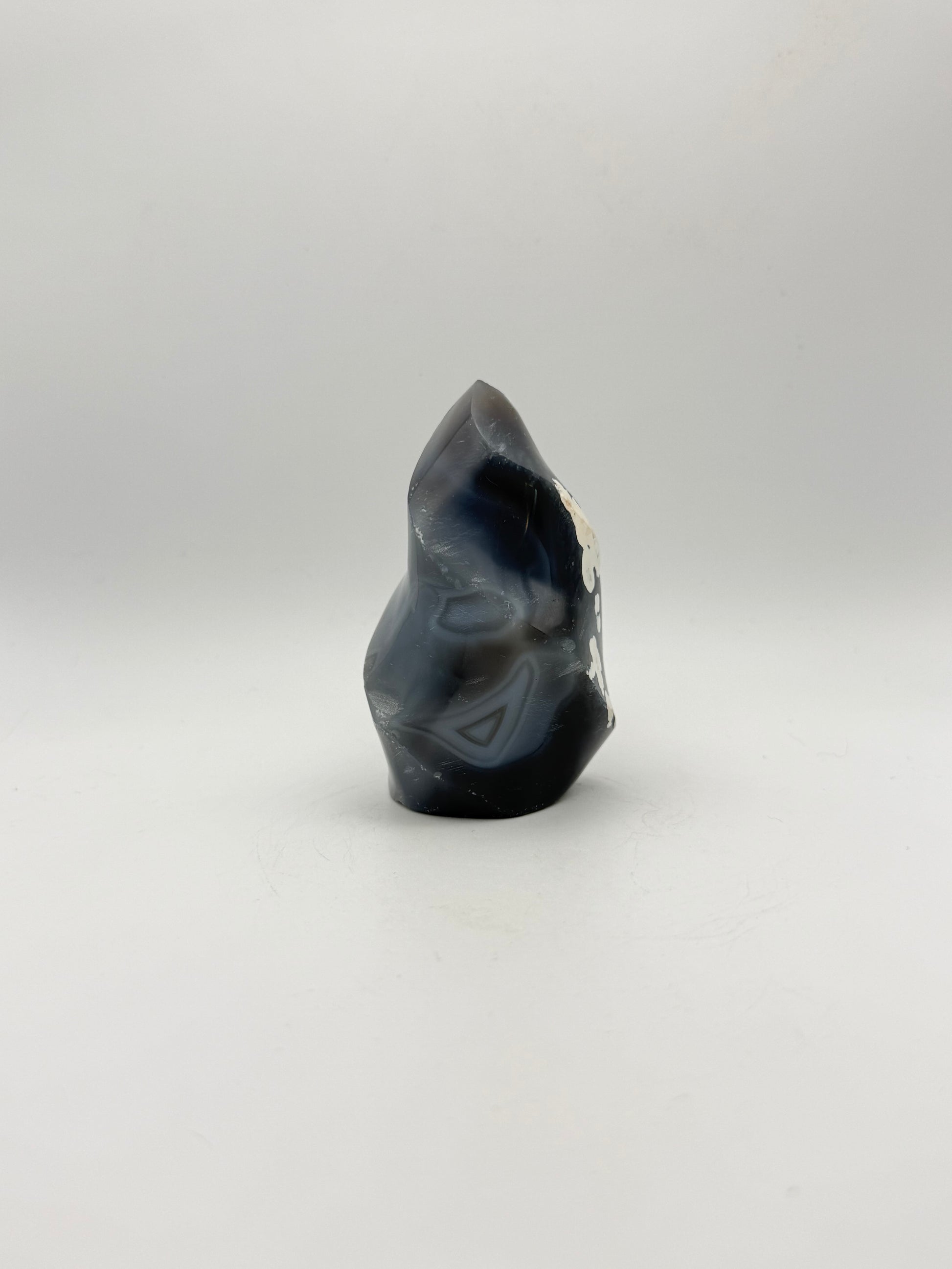 Polished orca agate in the shape of a flame.