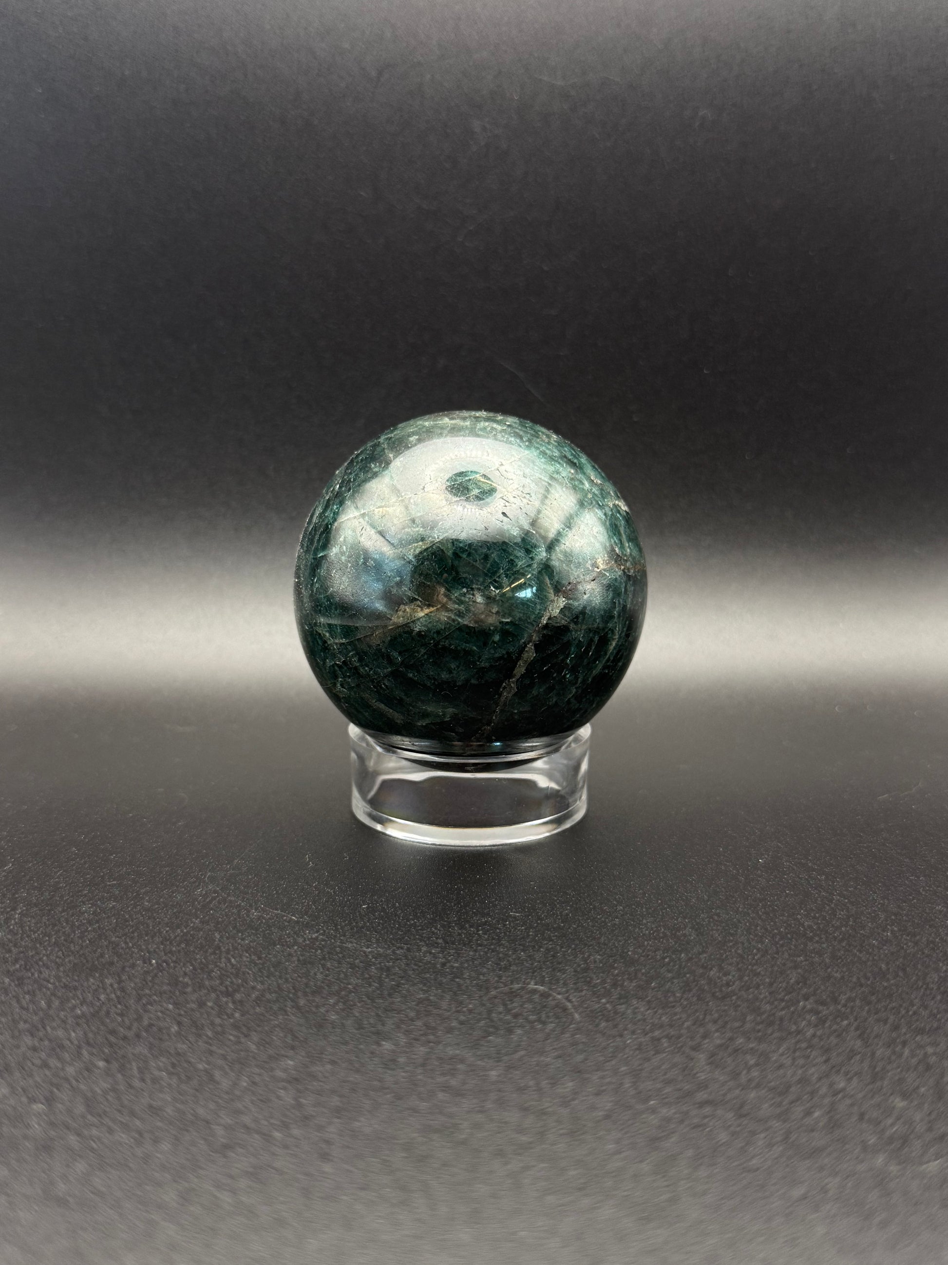 Polished green apatite crystal in the shape of a sphere.