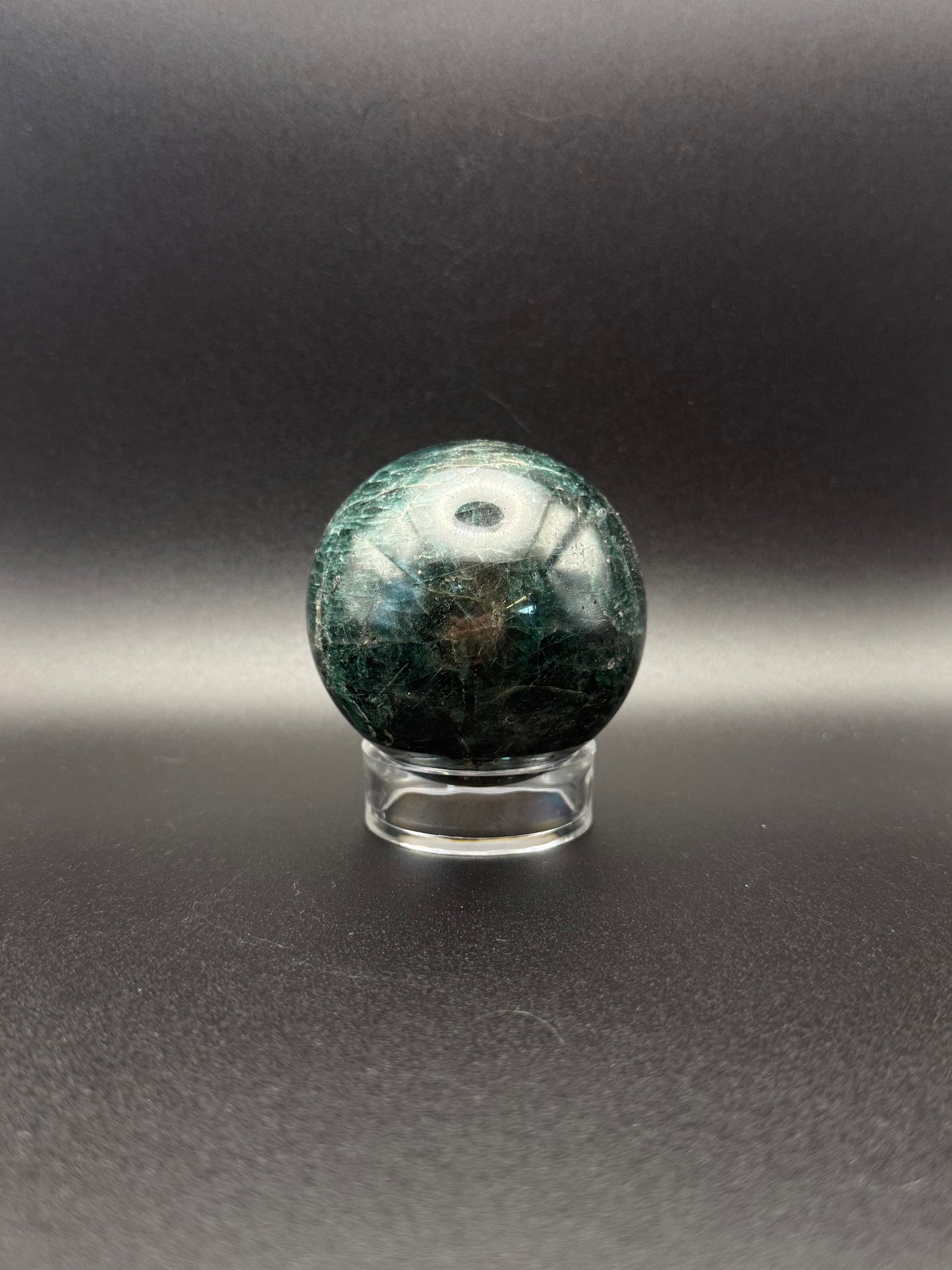 Polished green apatite crystal in the shape of a sphere.