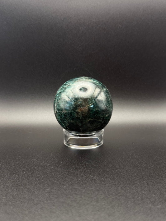 Polished green apatite crystal in the shape of a sphere.