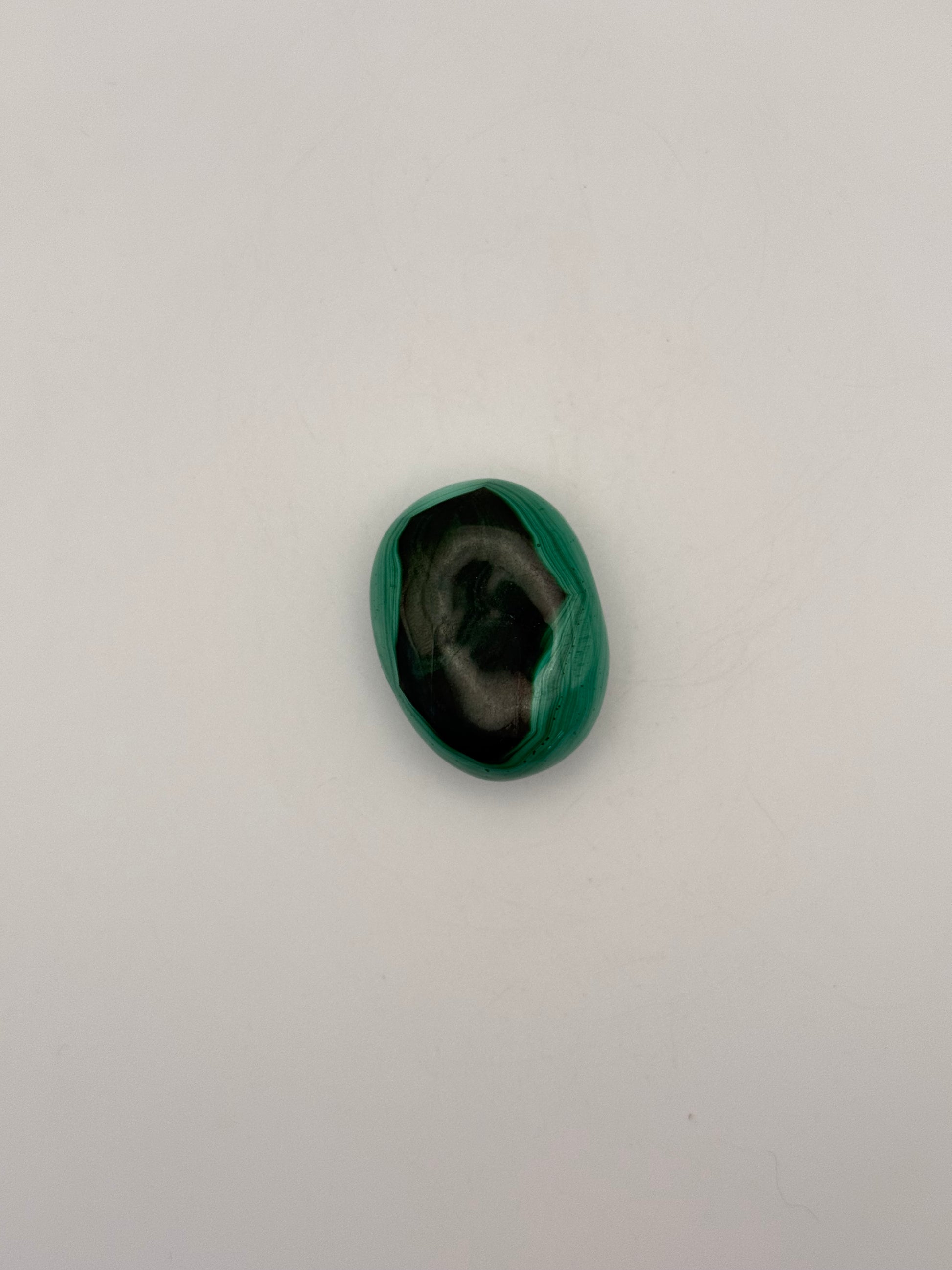 Vibrant green malachite palm stone with unique swirling patterns.