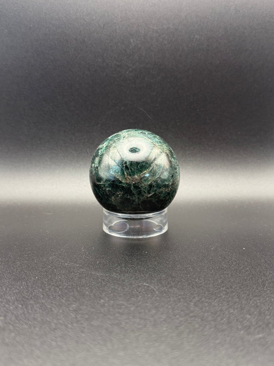 Polished green apatite crystal in the shape of a sphere.