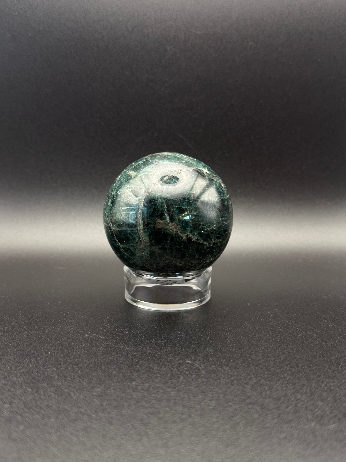 Polished green apatite crystal in the shape of a sphere.