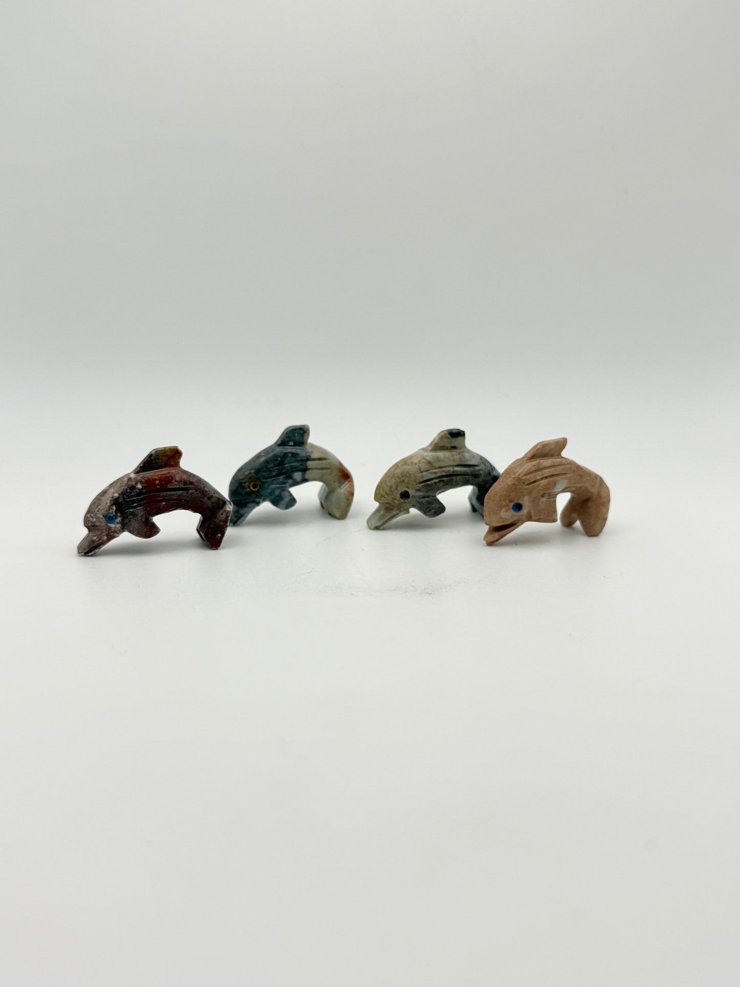 Small stone sculptures of animals arranged vertically on a white background