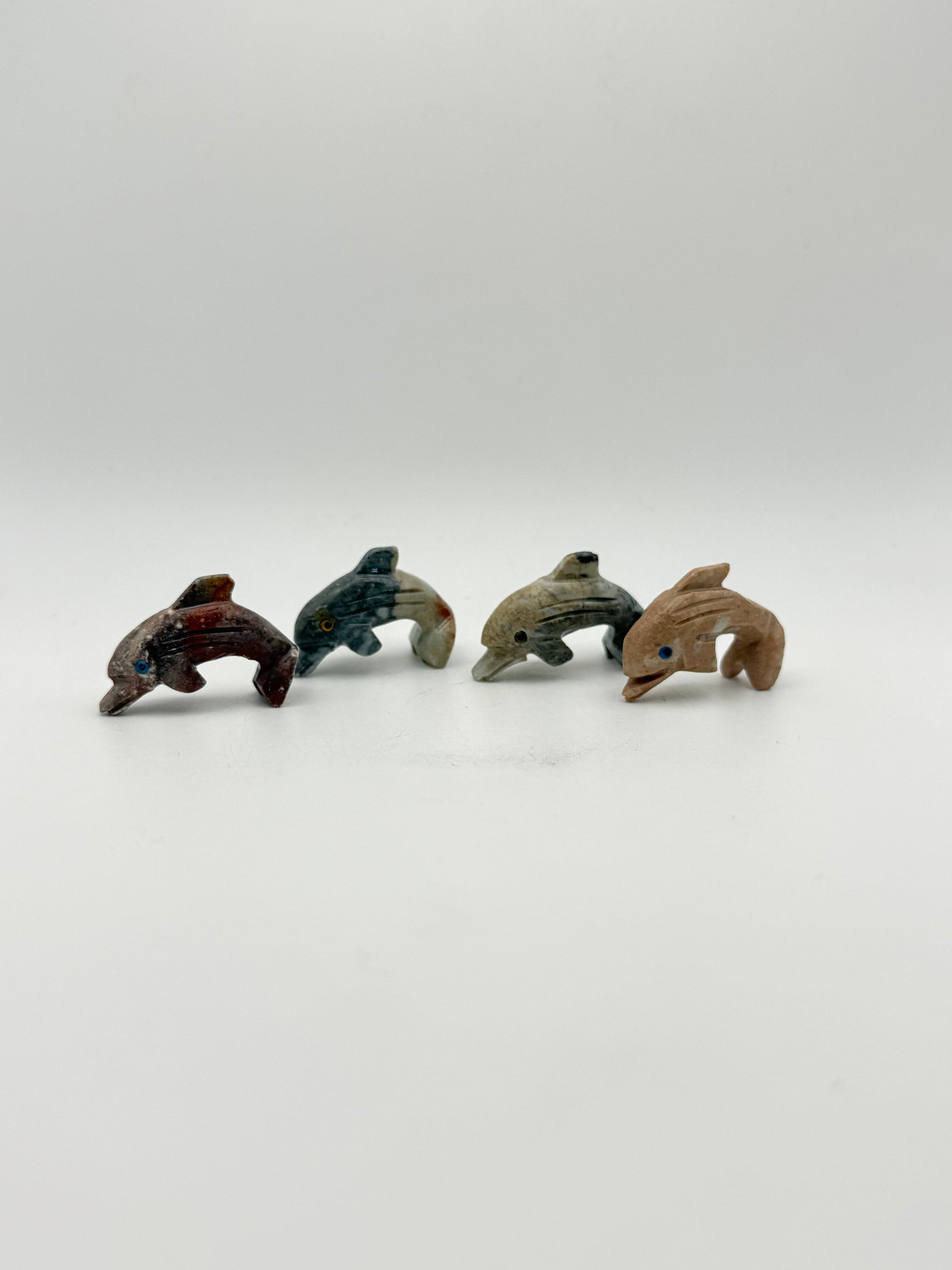 Small stone sculptures of animals arranged vertically on a white background