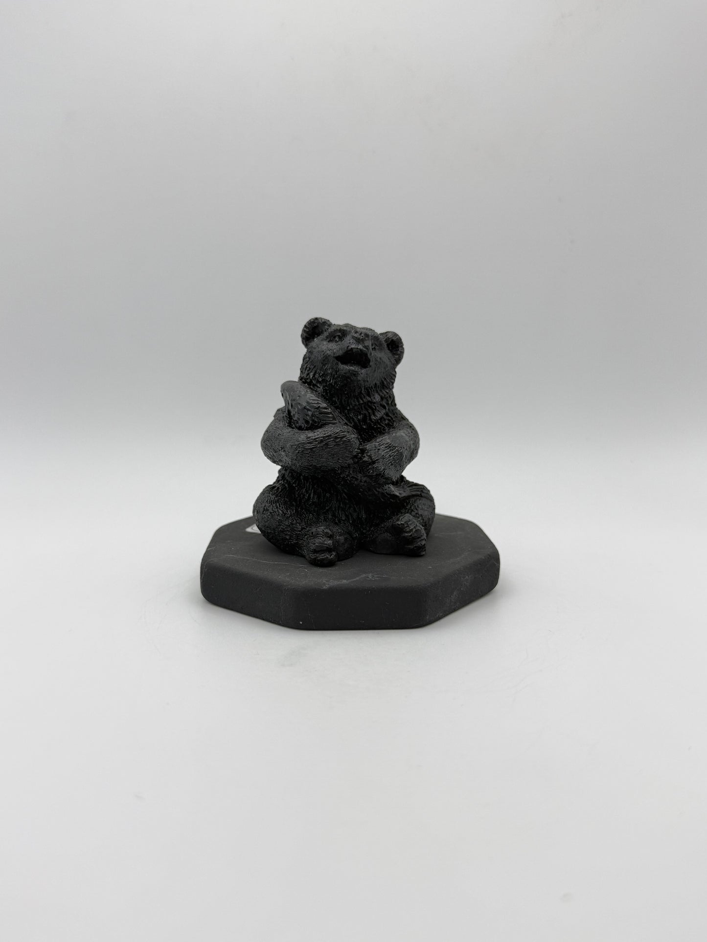 Shungite carving of a bear holding a fish.