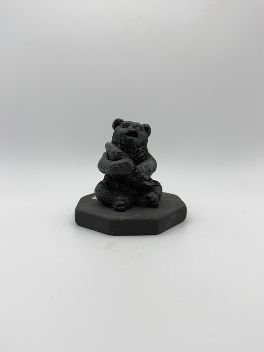 Shungite carving of a bear holding a fish.
