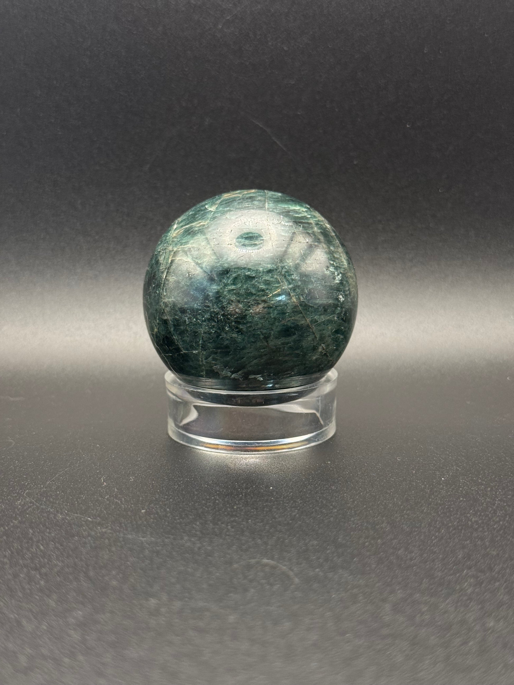 Polished green apatite crystal in the shape of a sphere.