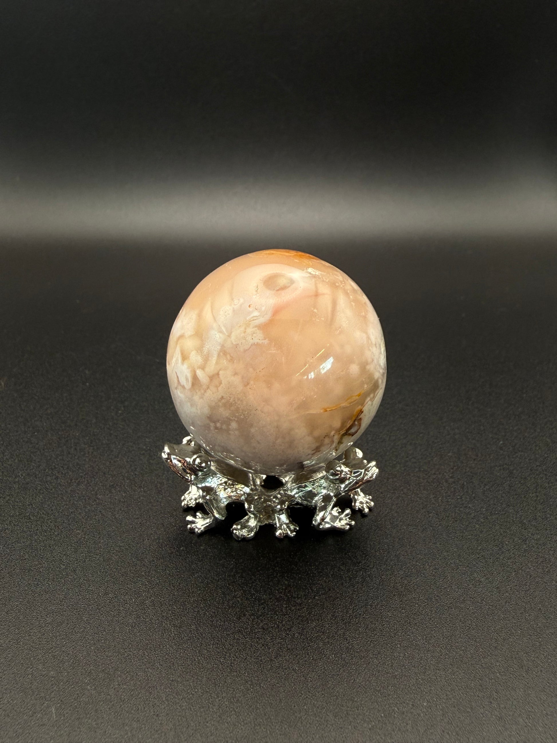 Flower agate polished crystal in the shape of a sphere.