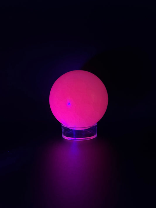 Polished pink calcite sphere. Pink calcite glows under uv light.