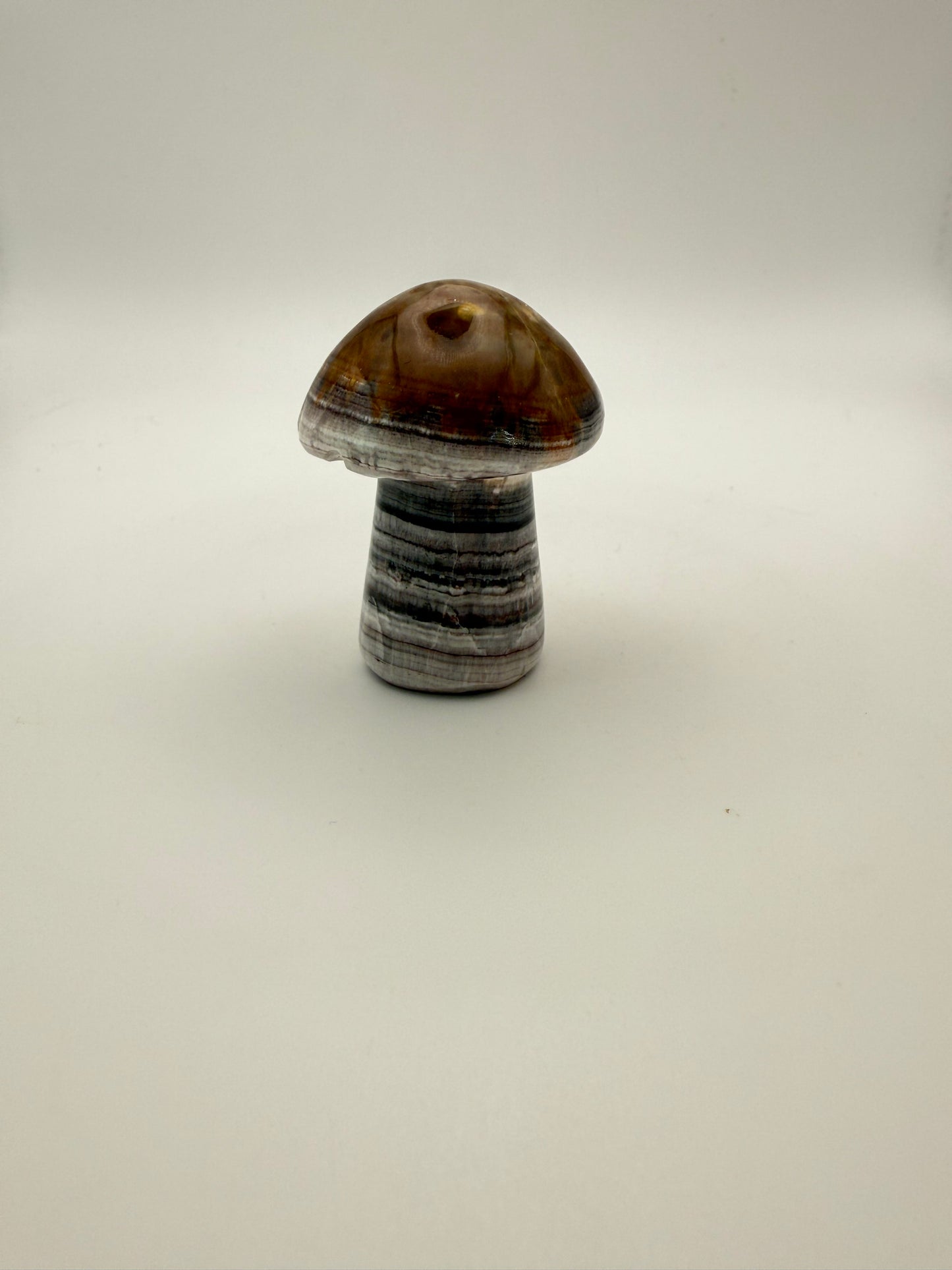 Polished chocolate calcite crystal shaped into a mushroom.