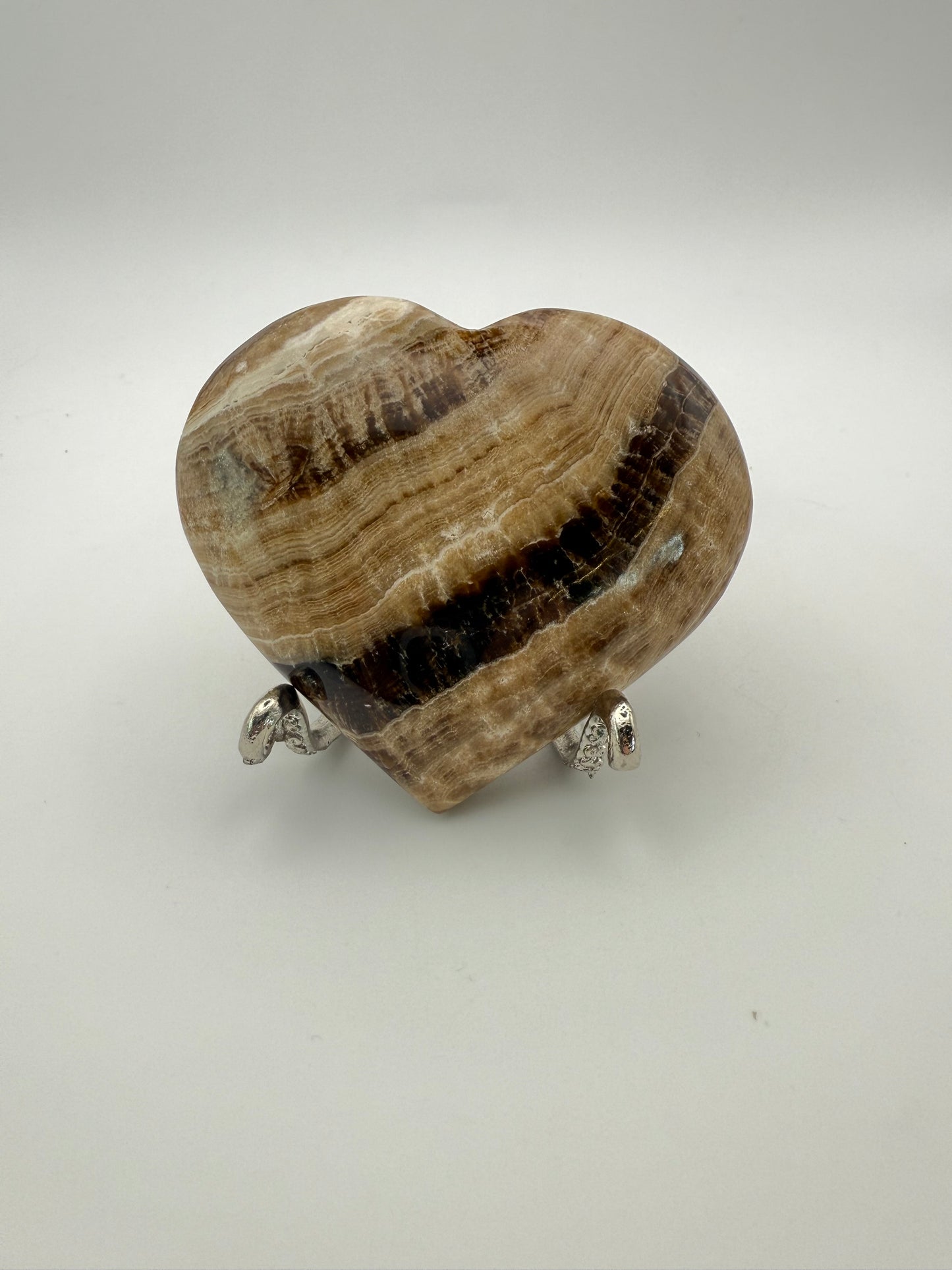 A polished chocolate calcite heart-shaped stone with a brown and white marbled pattern.