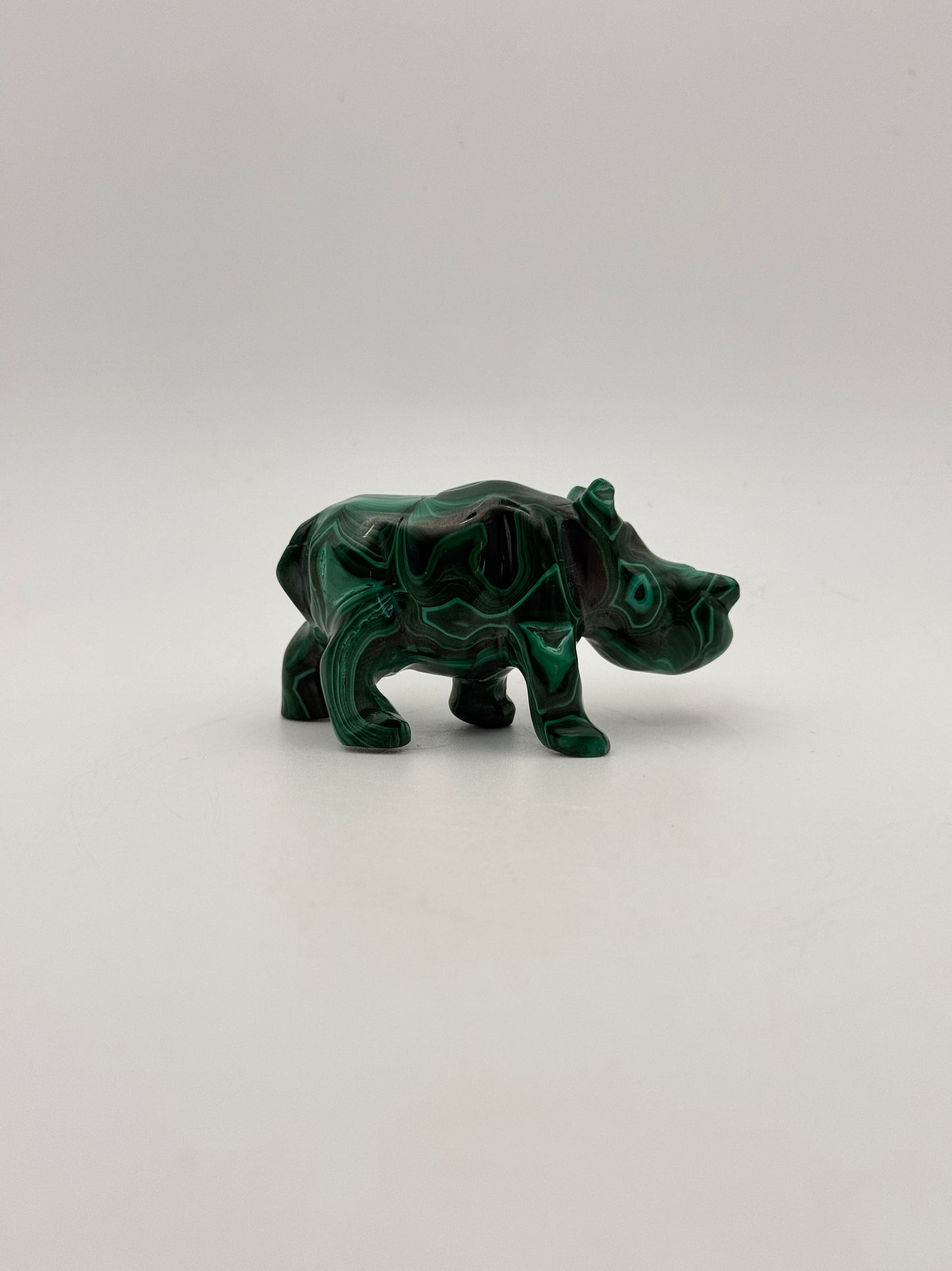 Vibrant green malachite stone carving of a rhino.