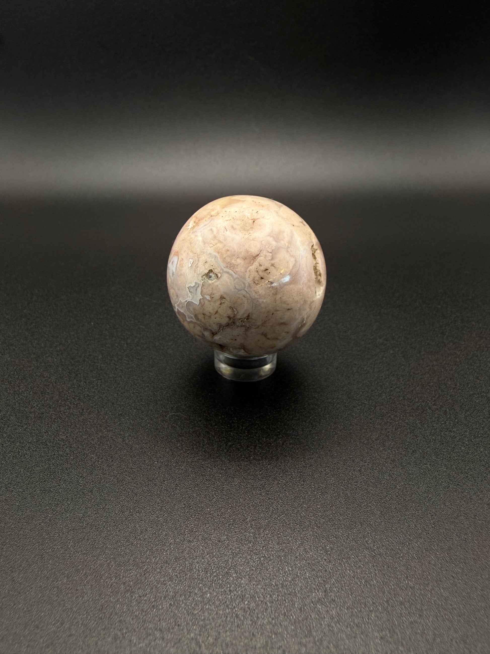 Flower agate polished crystal in the shape of a sphere.